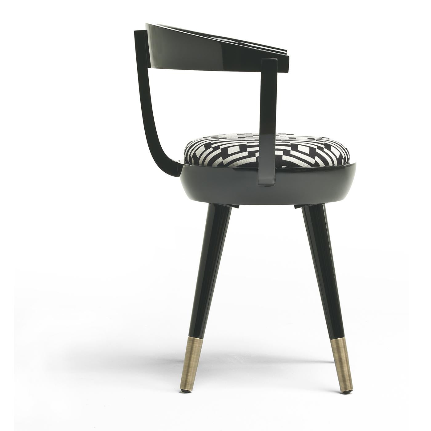 A fun and original design guaranteed to start a conversation, the Galleon Chair sits on flared midcentury modern-inspired legs with burnished brass feet. The chair with a unique backrest is then coated in a glossy black finish and upholstered with