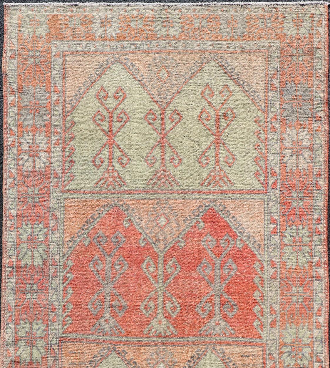 Turkish gallery rug with faded colors, rug EN-178032, country of origin / type: Turkey / Oushak, circa 1940

This fun and vibrant Oushak runner from 1930s features a unique block design of medallions with small tribal motifs in the in them. The