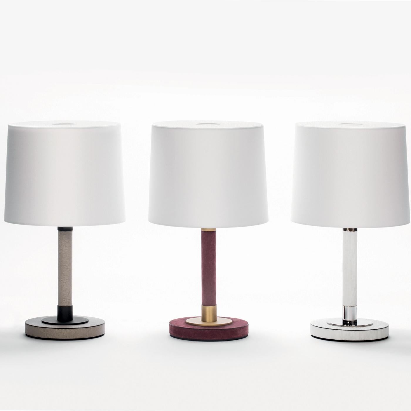 Great for lighting by a bedside or in a lounge, this contemporary design lamp has a white leather-covered wood base with polished chrome details (also bronze and brass on request) complemented by a crisp white cotton shade. Additional features