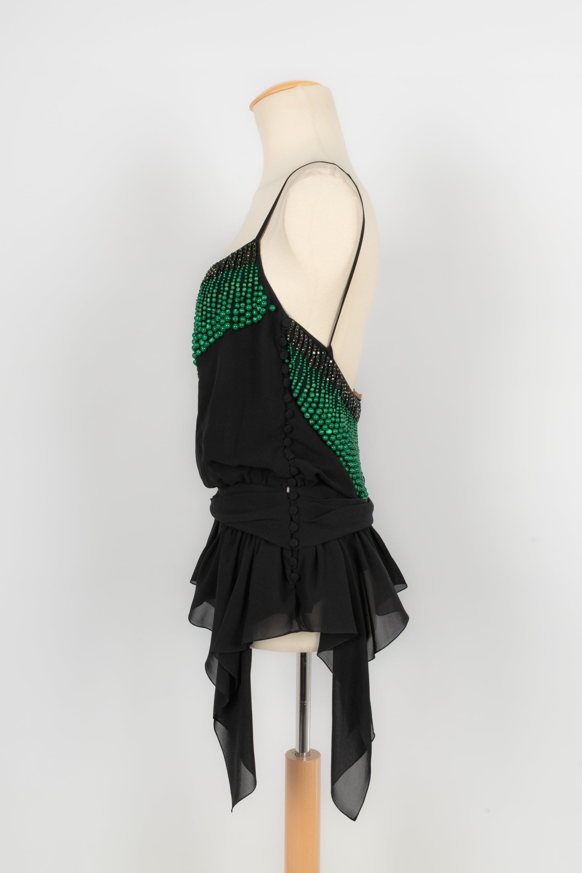 Galliano - Black top ornamented with pearls and green rhinestones. No size indicated, it fits a 36FR/38FR.

Additional information:
Condition: Very good condition
Dimensions: Chest: 44 cm
Length: 54 cm

Seller reference: FH39