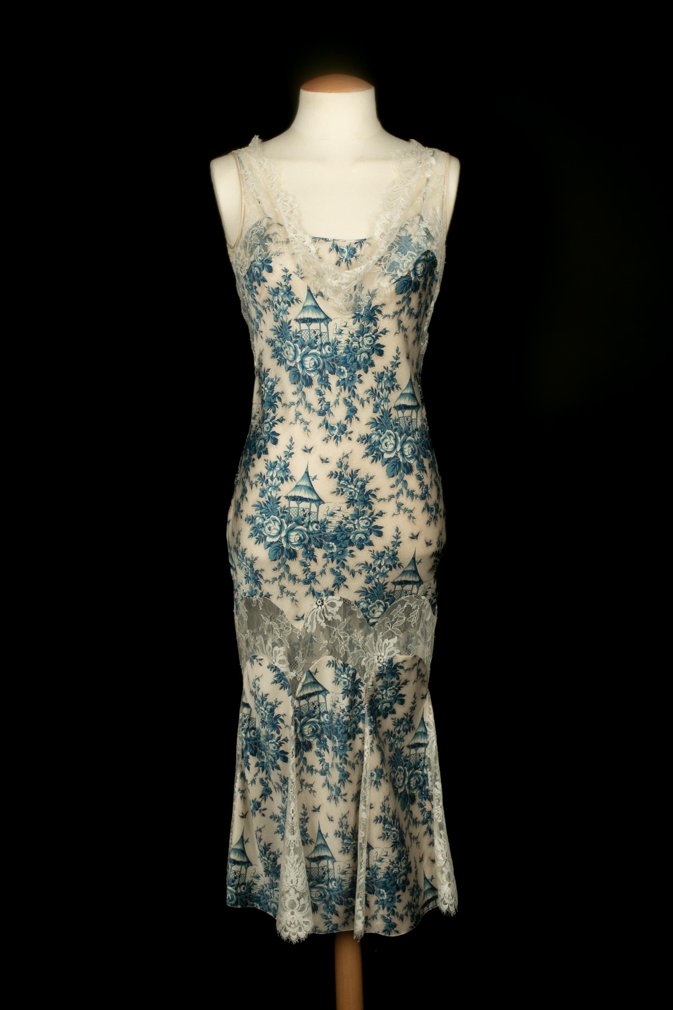 GALLIANO - (Fabricado en Francia) Vestido largo de satén blanco roto estampado con un motivo azul de inspiración china y con encaje blanco. Colección Otoño-Invierno 2003-2004 