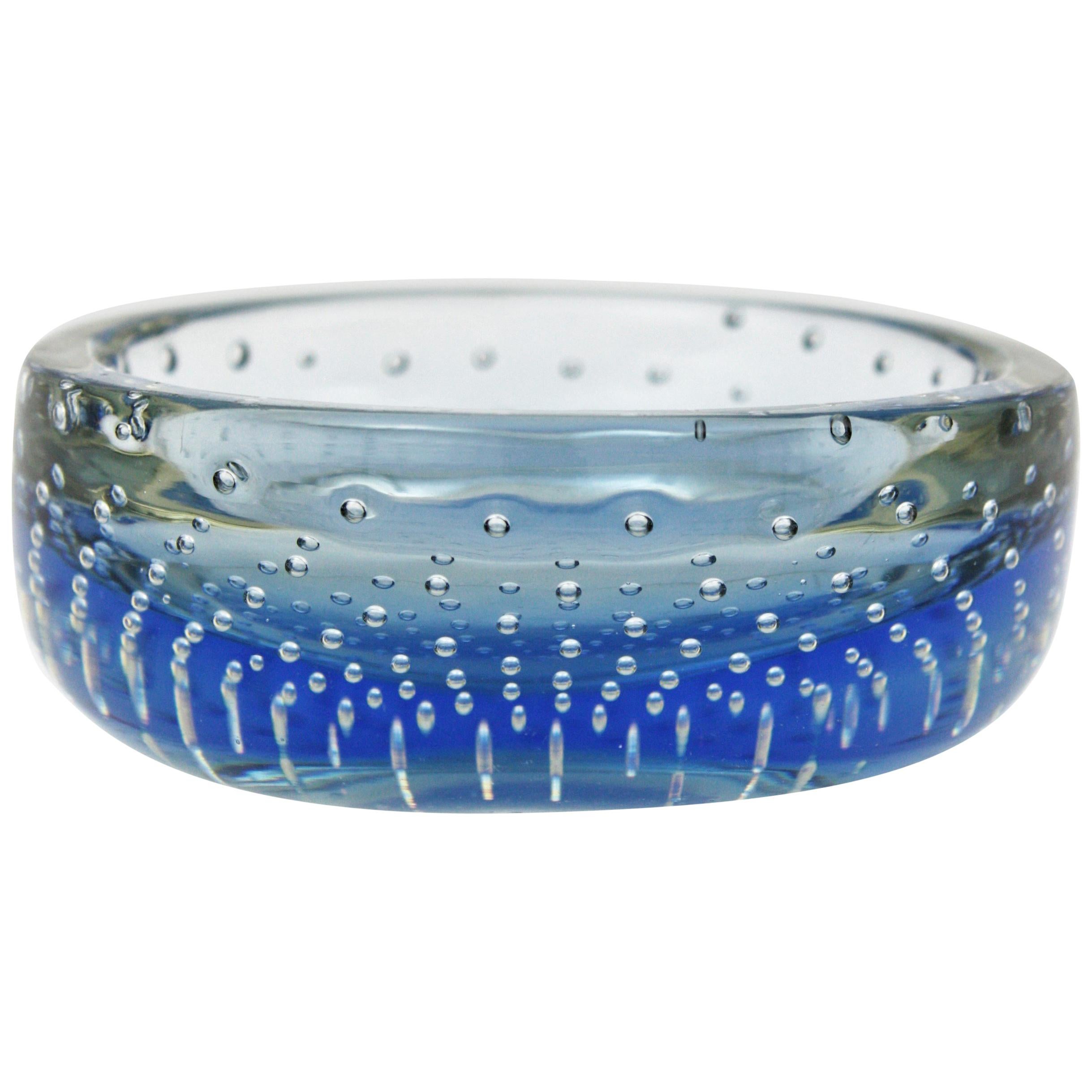 Coupe ou cendrier de forme ronde en verre bleu de Murano soufflé à la main, avec coupe à bulles contrôlées, attribuée à Galliano Ferro. Italie, années 1960.
Verre bleu encastré dans du verre clair selon la technique Sommerso. 
Joli pour être utilisé