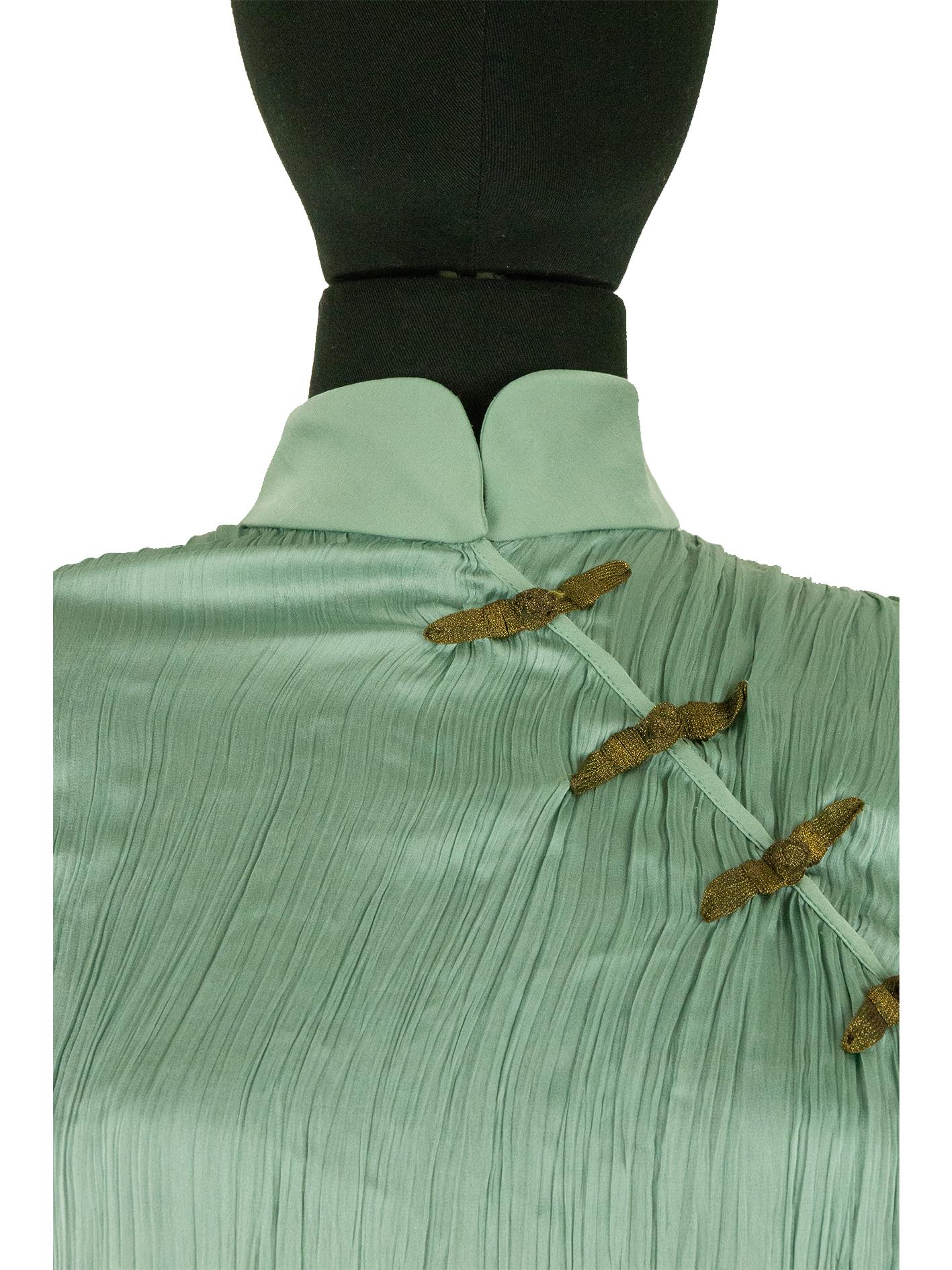 A 1999 Dior by Galliano green silk plissé cheongsam blouse. This traditional chinese cheongsam inspired blouse. In an interview with Vogue, Galliano explains that he was fascinated with Chinese culture; he gained this fascination through the help of