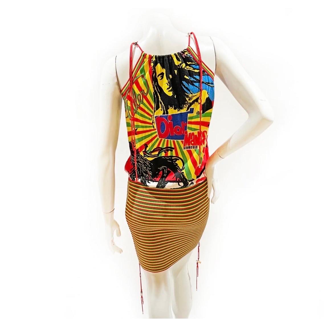 Rasta Mania Collection Dress by John Galliano for Dior  
Made in France
Spring/Summer 2004
Signature Rasta Mania logo graphics throughout top 
Red spaghetti straps
Body-con red, green & yellow striped skirt
Silver tightening toggles on shoulder