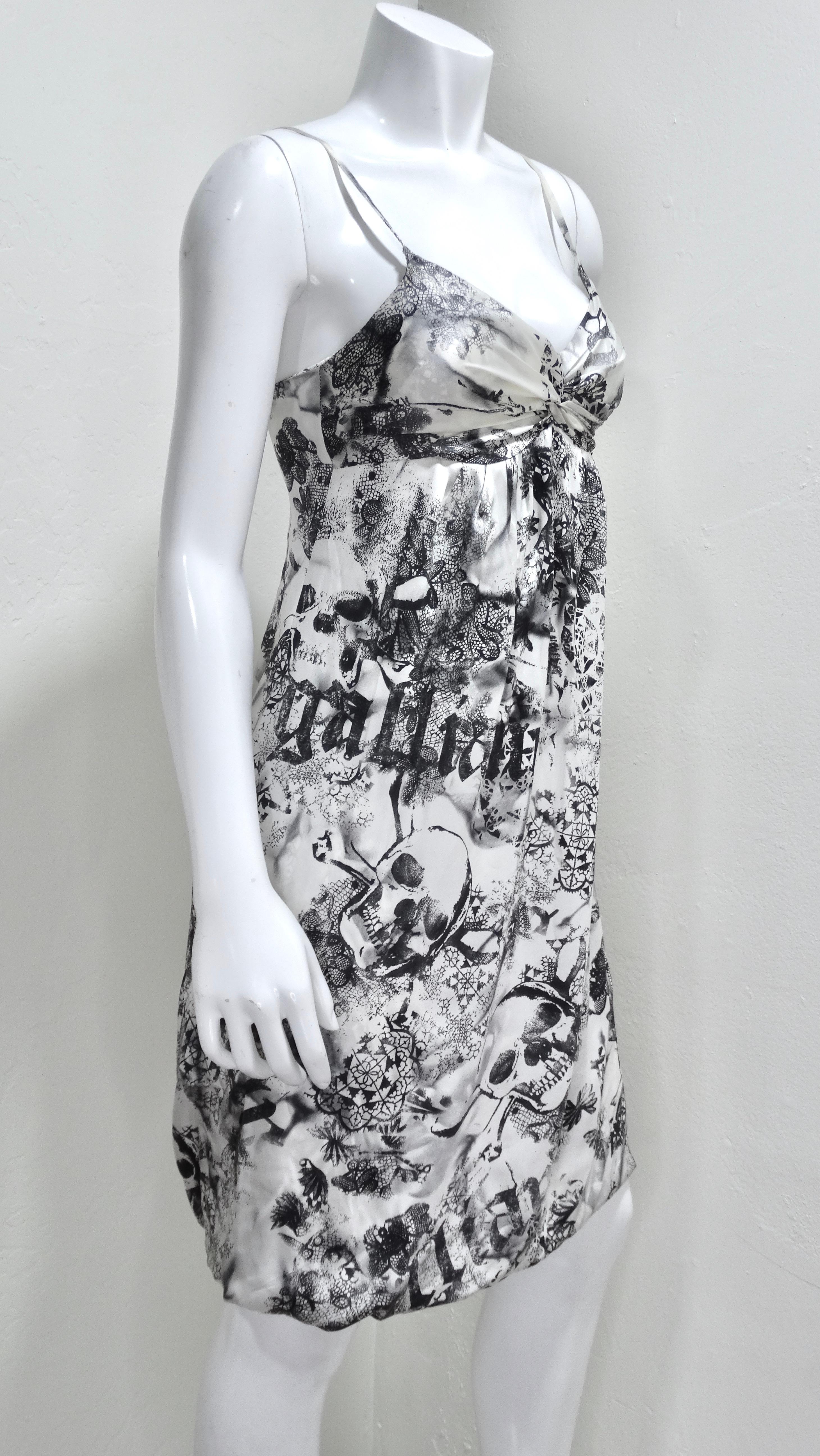 Bring out your rocker-chick for this Galliano era printed knee-length dress. This is a slip-style dress, double lined, with a flattering twisted bust, thin straps, and a 'Galliano' and skull black and white print throughout. Pair with some Celine