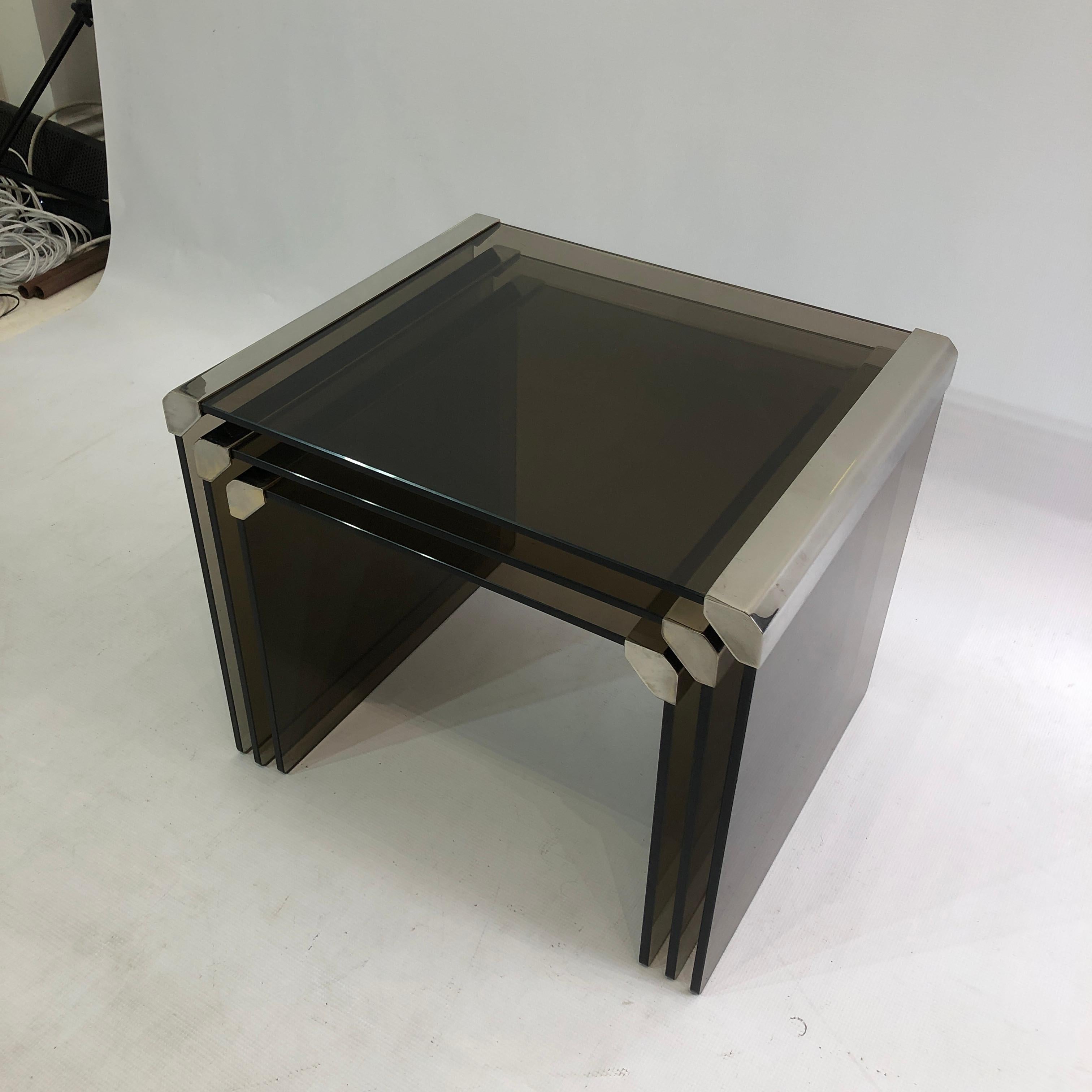 Nest of 1980s Italian tables in chrome frame and brown smoked tempered glass, from design powerhouses Gallotti & Radice. Imported from Italy to the UK in the 1990s.

The smoked glass sits in a chrome frame, with a modernist polygonal edge.  

Very