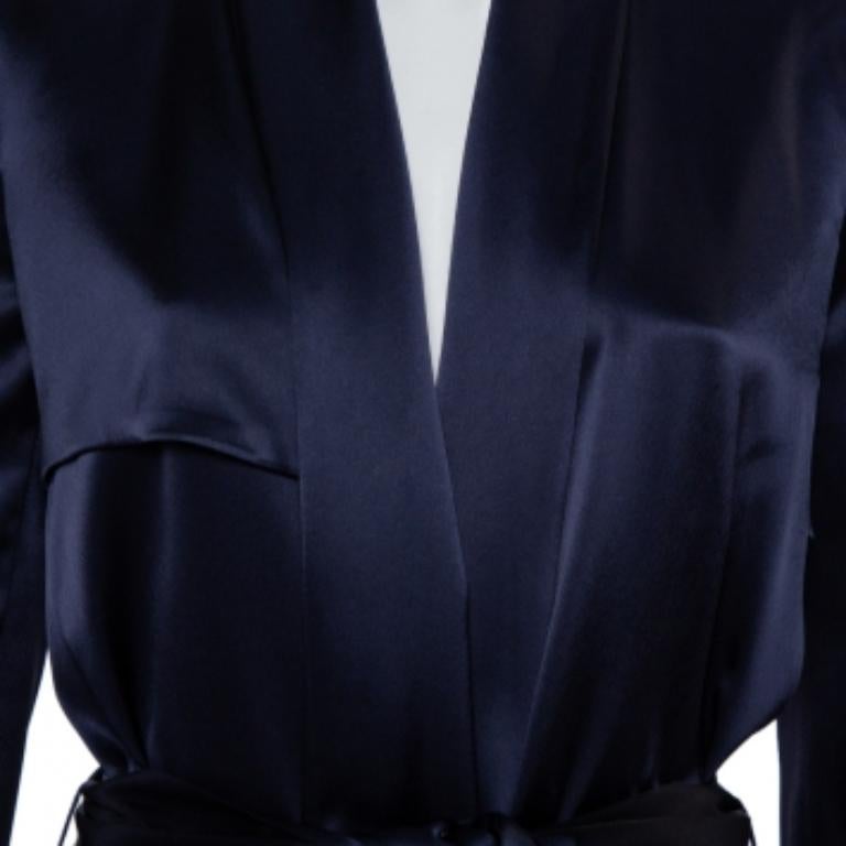 A classic style and a luxurious material result in this masterpiece by Galvan. This creation exudes elegance and is great for casual wear. Crafted from midnight blue satin, this trench coat is a must-have. It features a simple neckline, a belt that