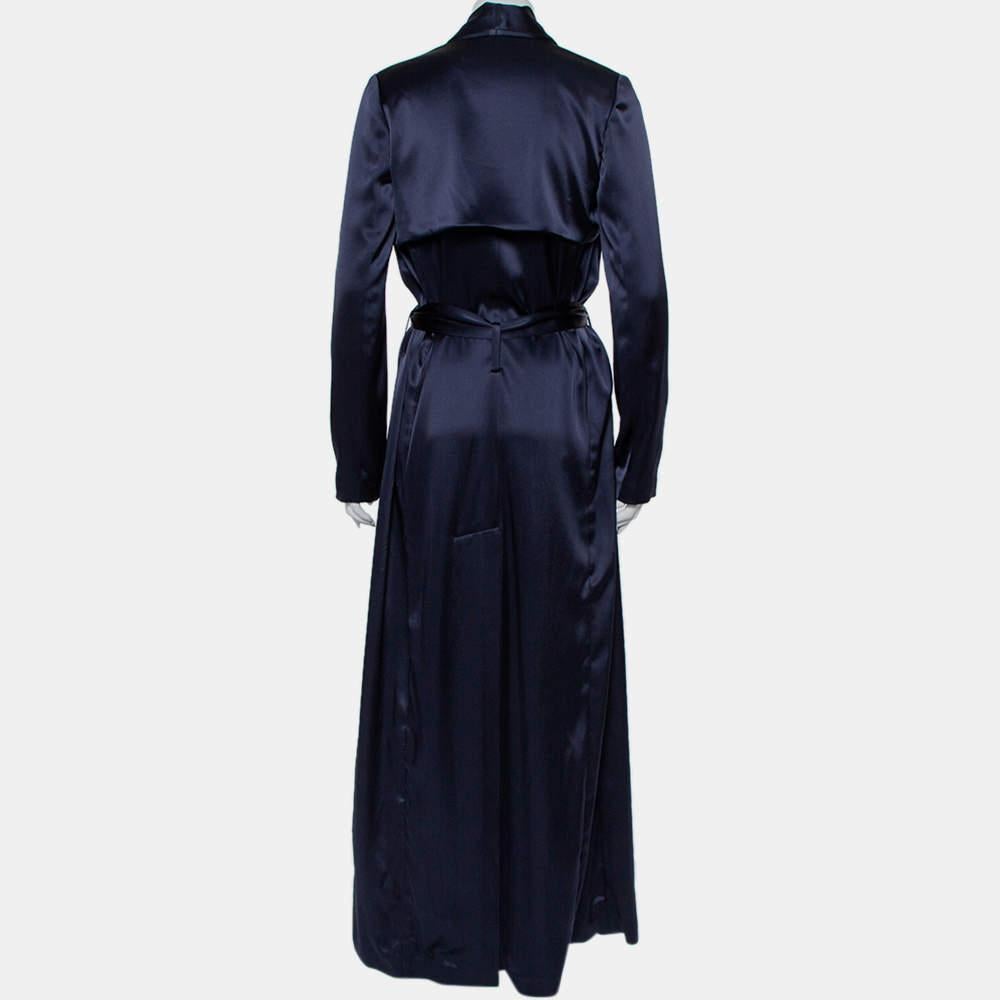 A classic style and a luxurious material result in this masterpiece by Galvan. This creation exudes elegance and is great for casual wear. Crafted from midnight blue satin, this trench coat is a must-have. It features a simple neckline, a belt that