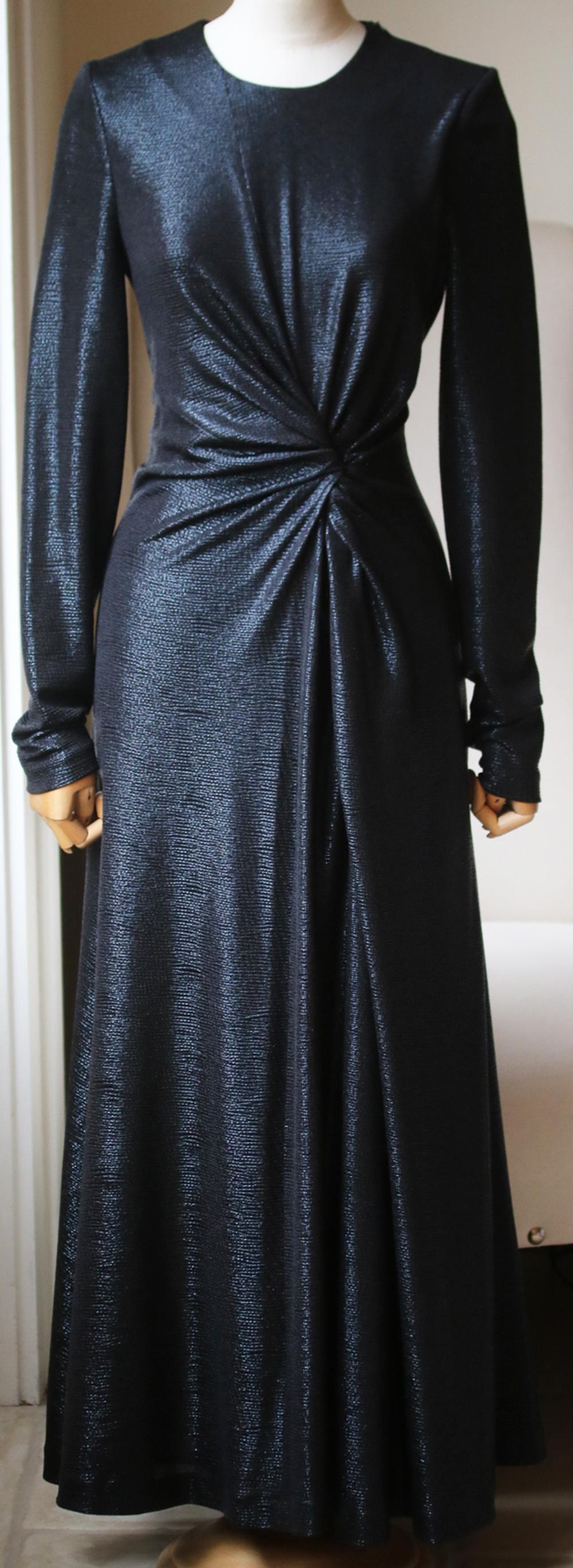 Shimmering metallic dress with a twist-front detail that drapes down to a swinging skirt that has a thigh-high side slit. Round neck. Long sleeves. Concealed zip closure. In black. 95% polyester, 5% spandex. 

Size: UK 10 (UK 6, FR 38, IT