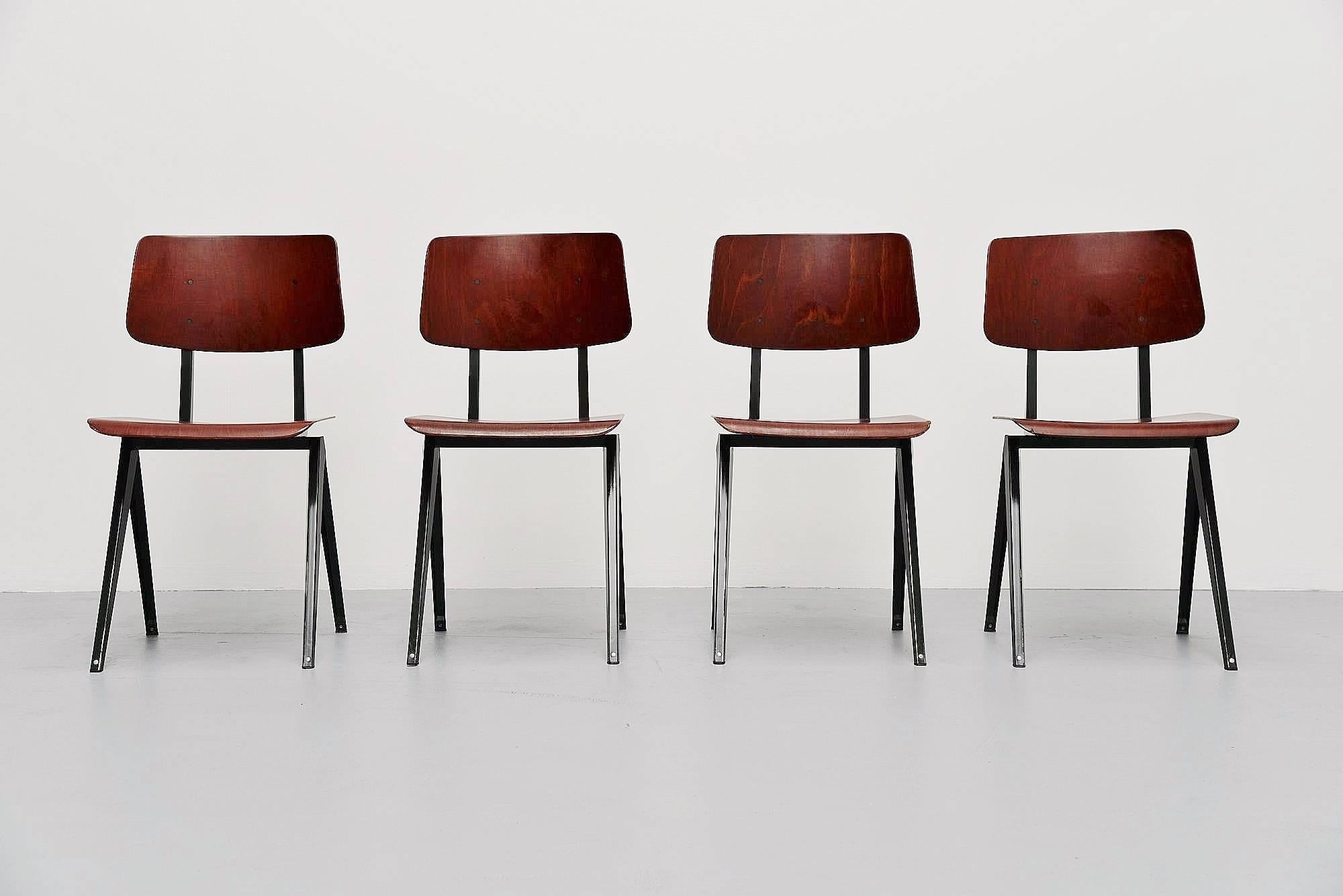 Very nice set of four industrial chairs made and designed by Galvanitas Oosterhout, Holland 1970. These chairs have a very nice dark grey lacquered metal frame and a redbrown pagwooden seat and back. This is for a nice and clean set of 4 chairs in