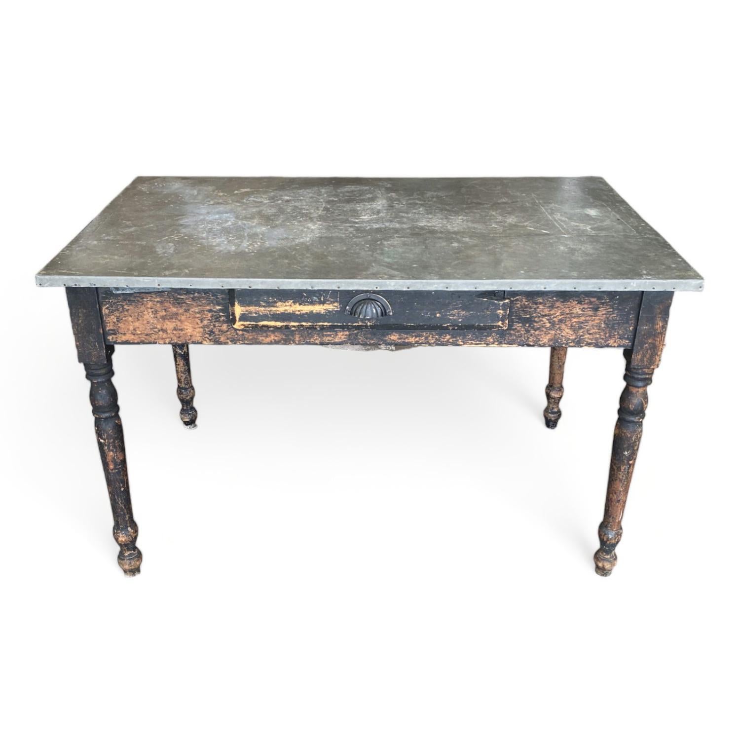 This unique writing desk is a rare find. The galvanized metal surface adds an industrial edge to a rustic American style. The unique surface provides a durable and practical workspace and with an added drawer, it would function perfectly for a