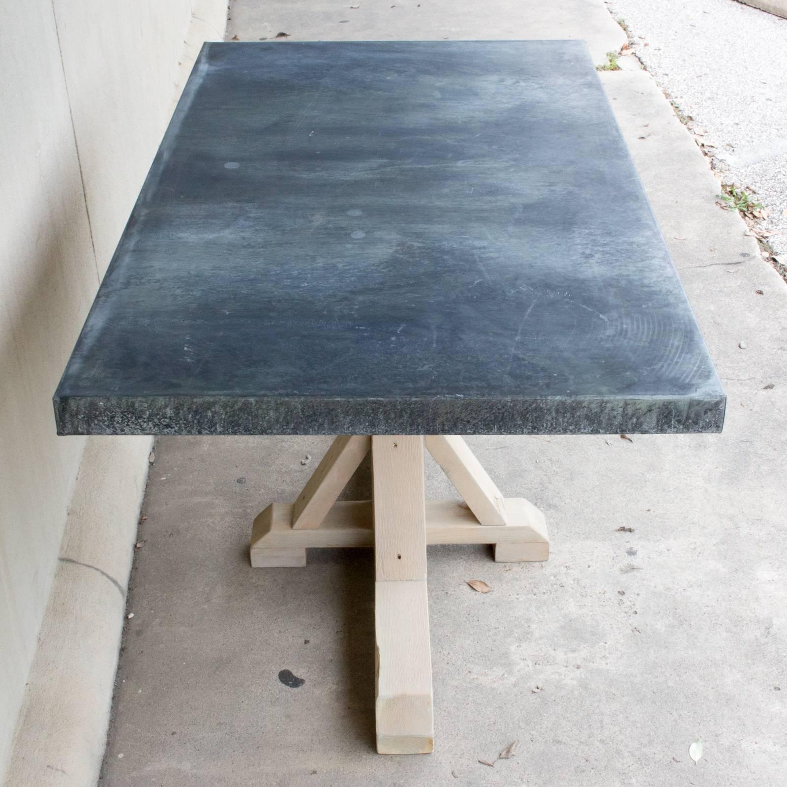 This handmade table is constructed with a wood base and galvanized zinc metal top. The pine base has been treated with a grey-toned wash to give the piece a lighter feel. Makes for a beautiful addition to your kitchen or in a breakfast nook, but