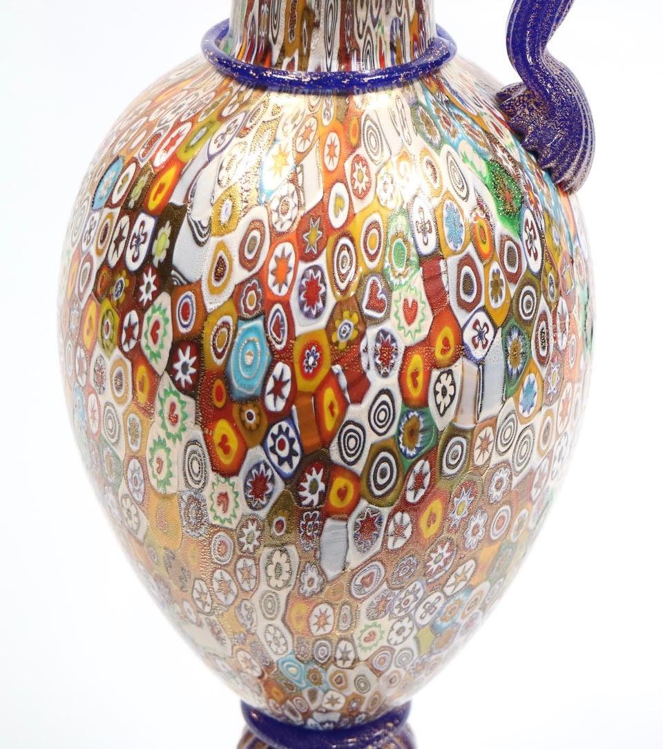 Italian Hollywood Regency monumental Murano glass ewer made with the millefiori glass technique, with gold Inclusions and details in cobalt blue and gold. The piece is signed on the bottom and was handmade in Italy during the 1950s. In excellent