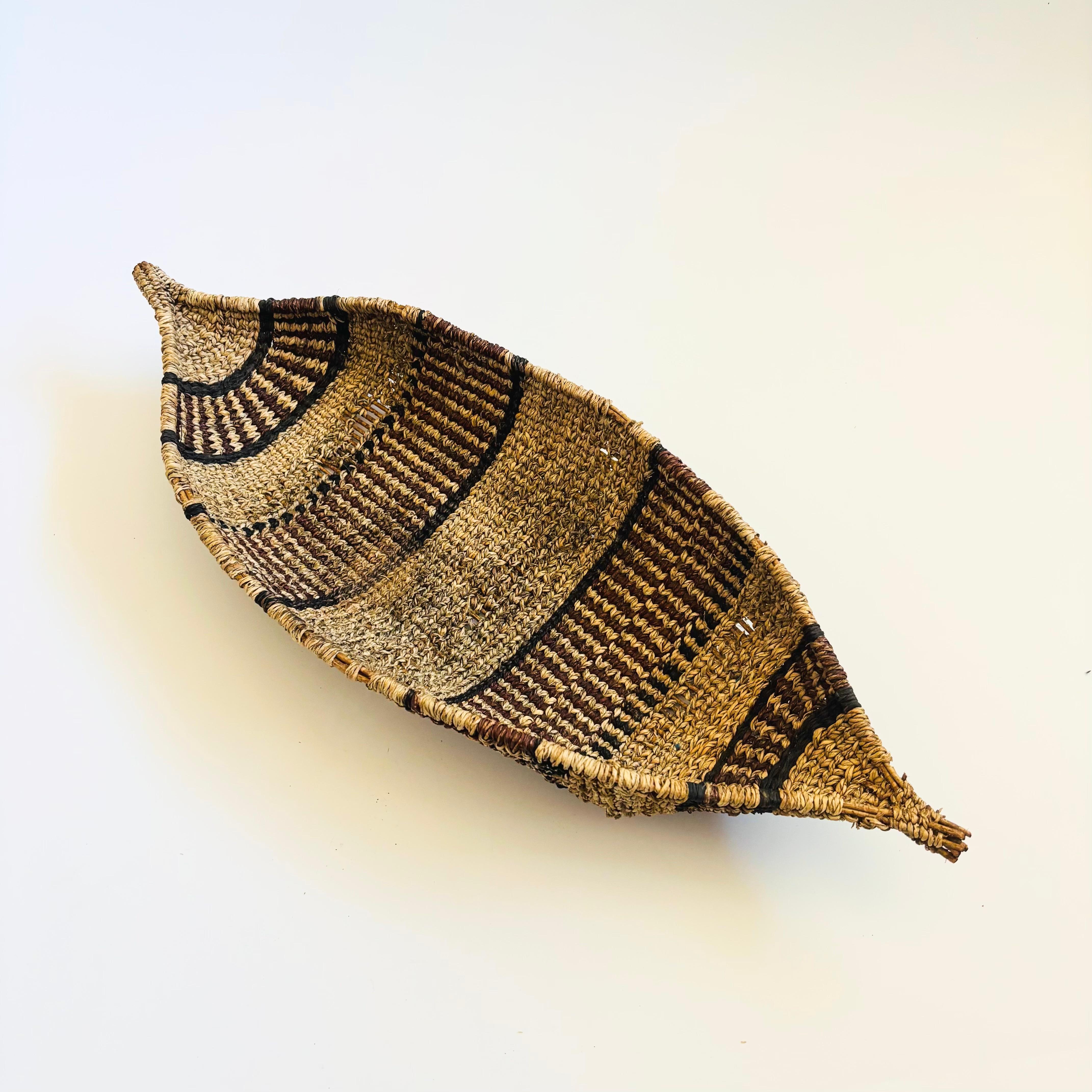 A vintage basket from the Gambela region of Ethiopia. Unique canoe shape with two tones of woven fibers.

