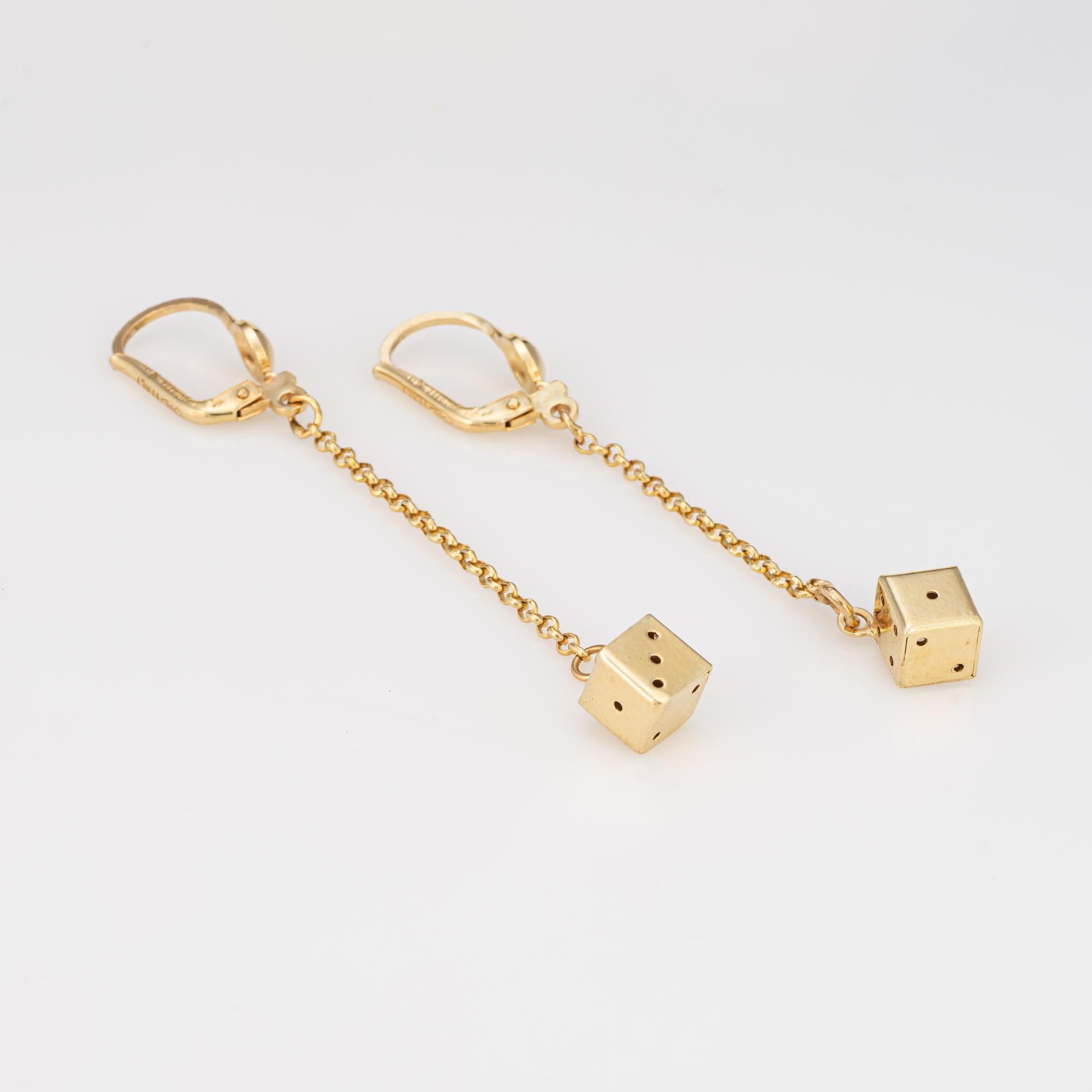 Finely detailed pair of gambling dice earrings crafted in 12k yellow gold. 

Small gambling dice adorns the base of the long 2 1/4 inch drops. Fitted with hook and lever backings for a secure fit on the earlobe. The earrings are great for day or