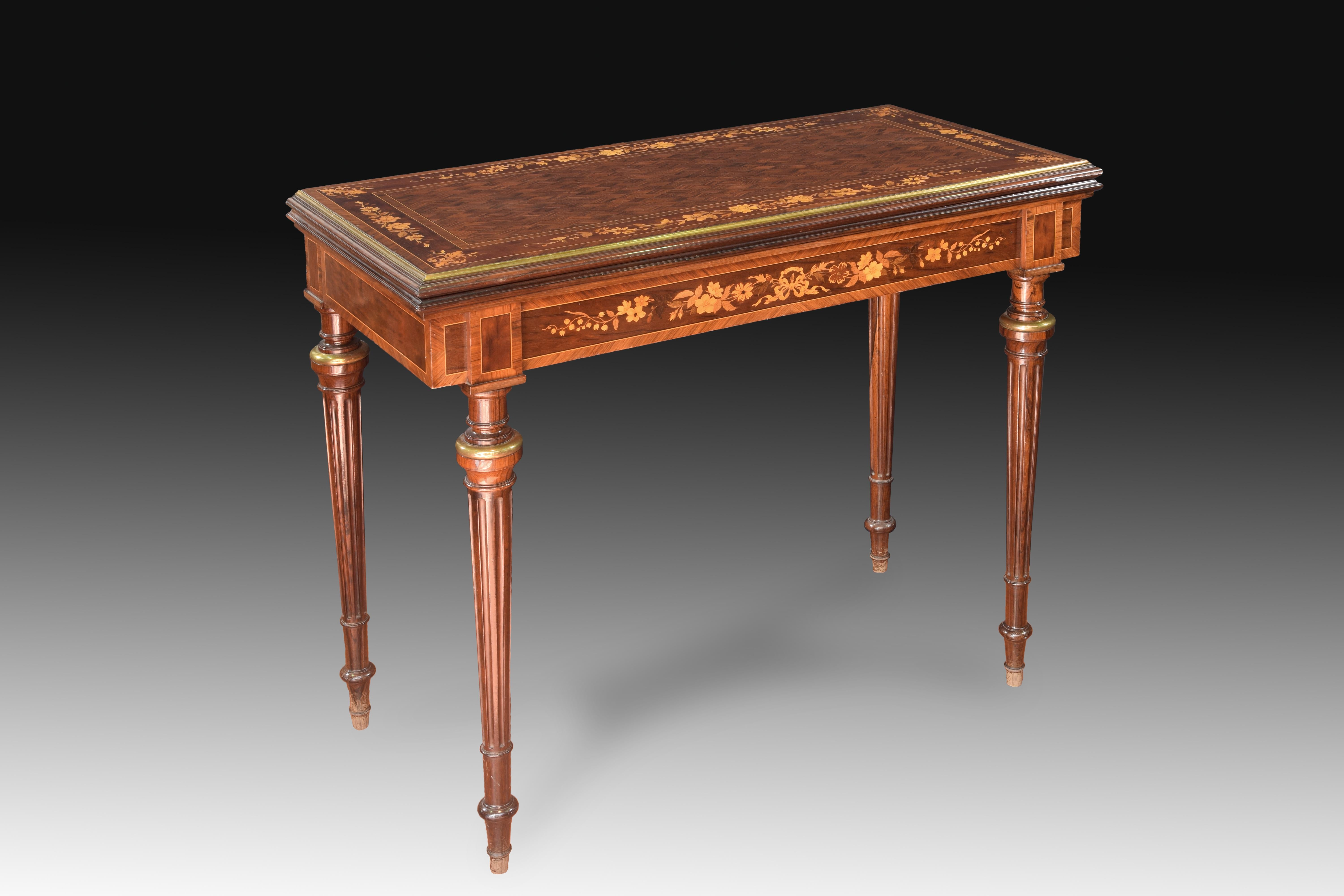 Game table with marquetry. Rosewood (palo santo), mahogany, fruit tree wood, bronze, leather, 19th century.
Table with four ribbed legs with metallic elements towards the top that has a delicate decoration in marquetry (flowers, bows, plant