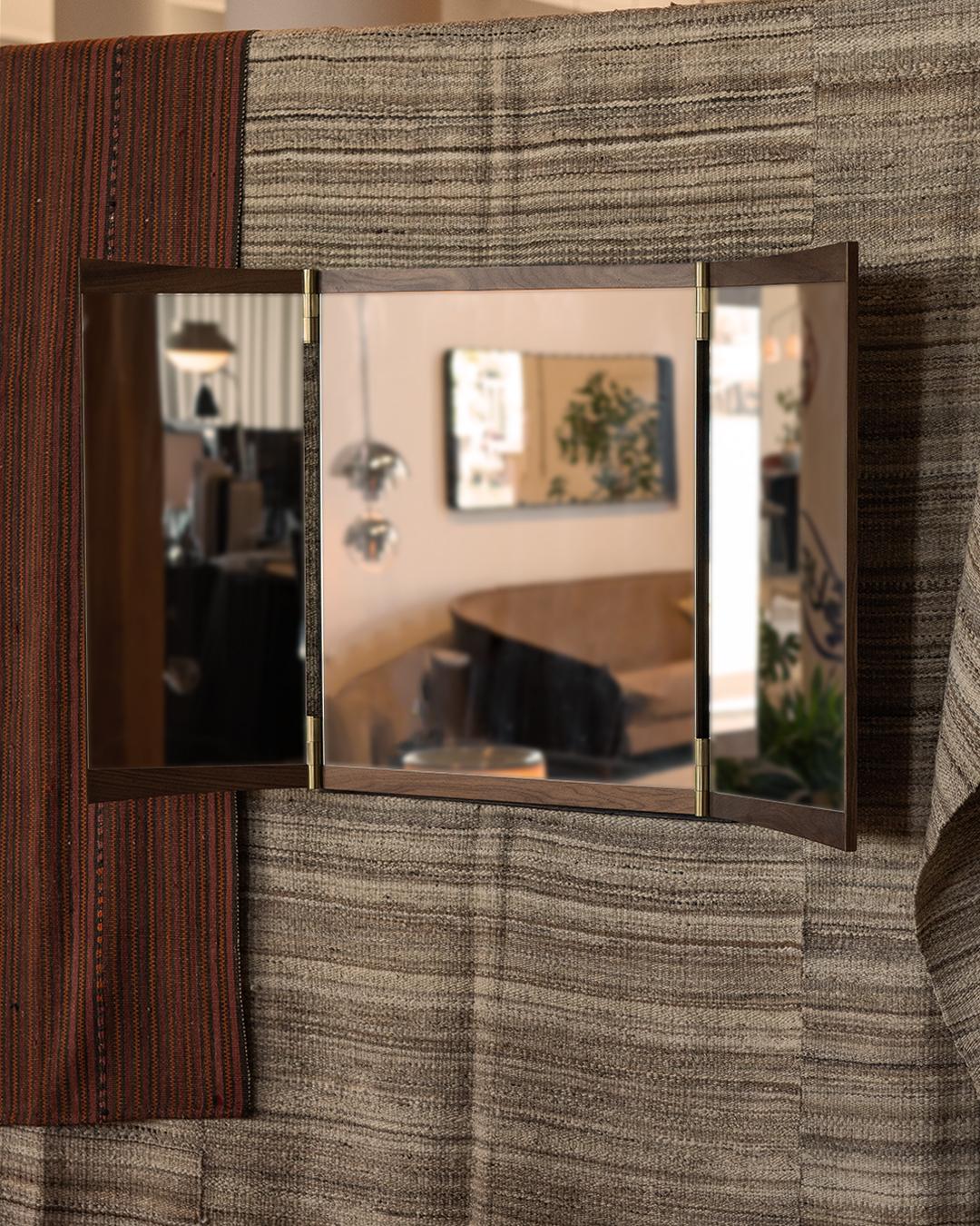 Miroir de courtoisie à trois panneaux pour Gubi.

Cette nouvelle collection de miroirs muraux réinvente ingénieusement le miroir de courtoisie pour les intérieurs contemporains. Exécuté en noyer et en laiton, le miroir Vanity incarne la capacité de