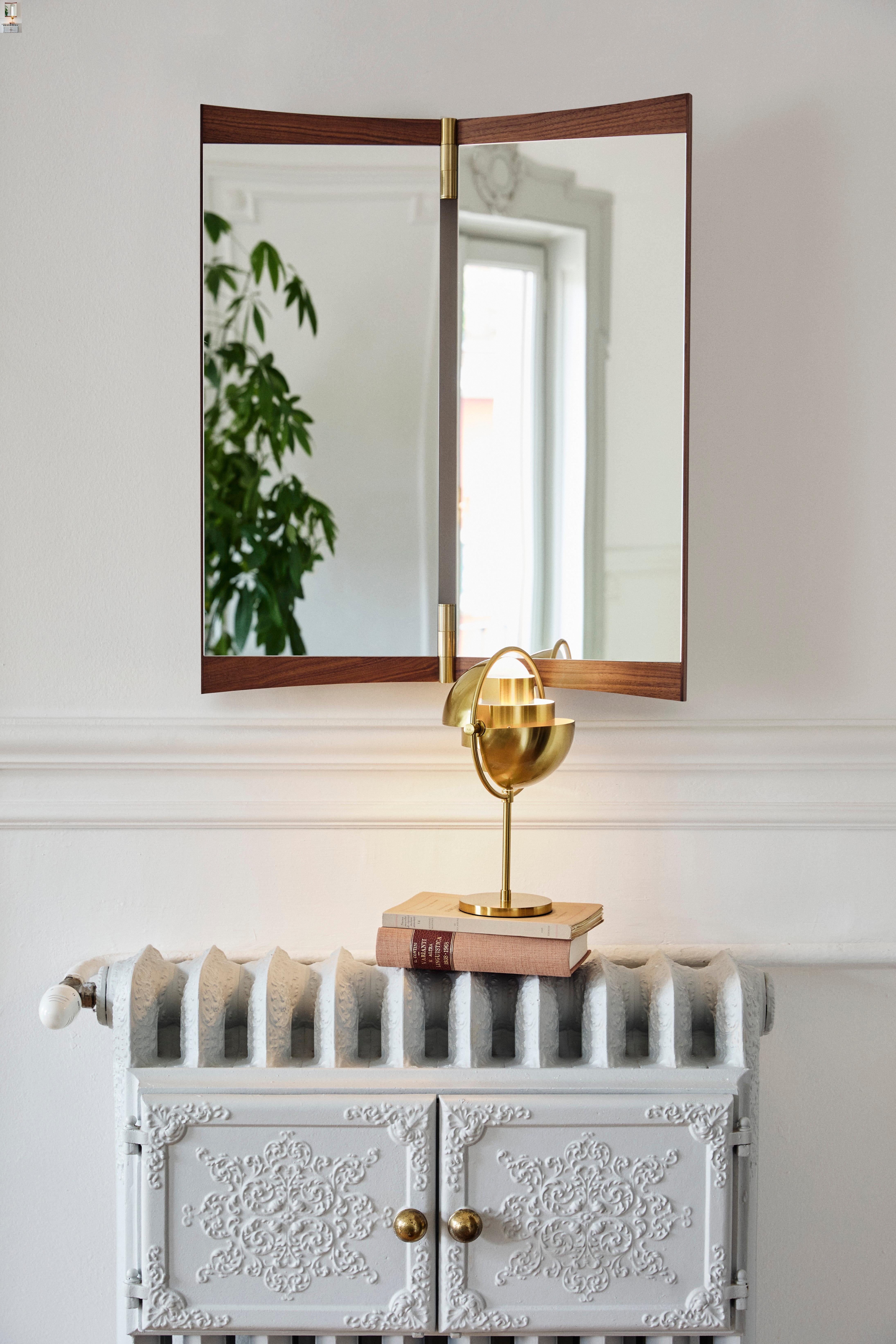 Miroir de courtoisie à deux panneaux pour Gubi.

Cette nouvelle collection de miroirs muraux réinvente ingénieusement le miroir de courtoisie pour les intérieurs contemporains. Exécuté en noyer et en laiton, le miroir Vanity incarne la capacité de