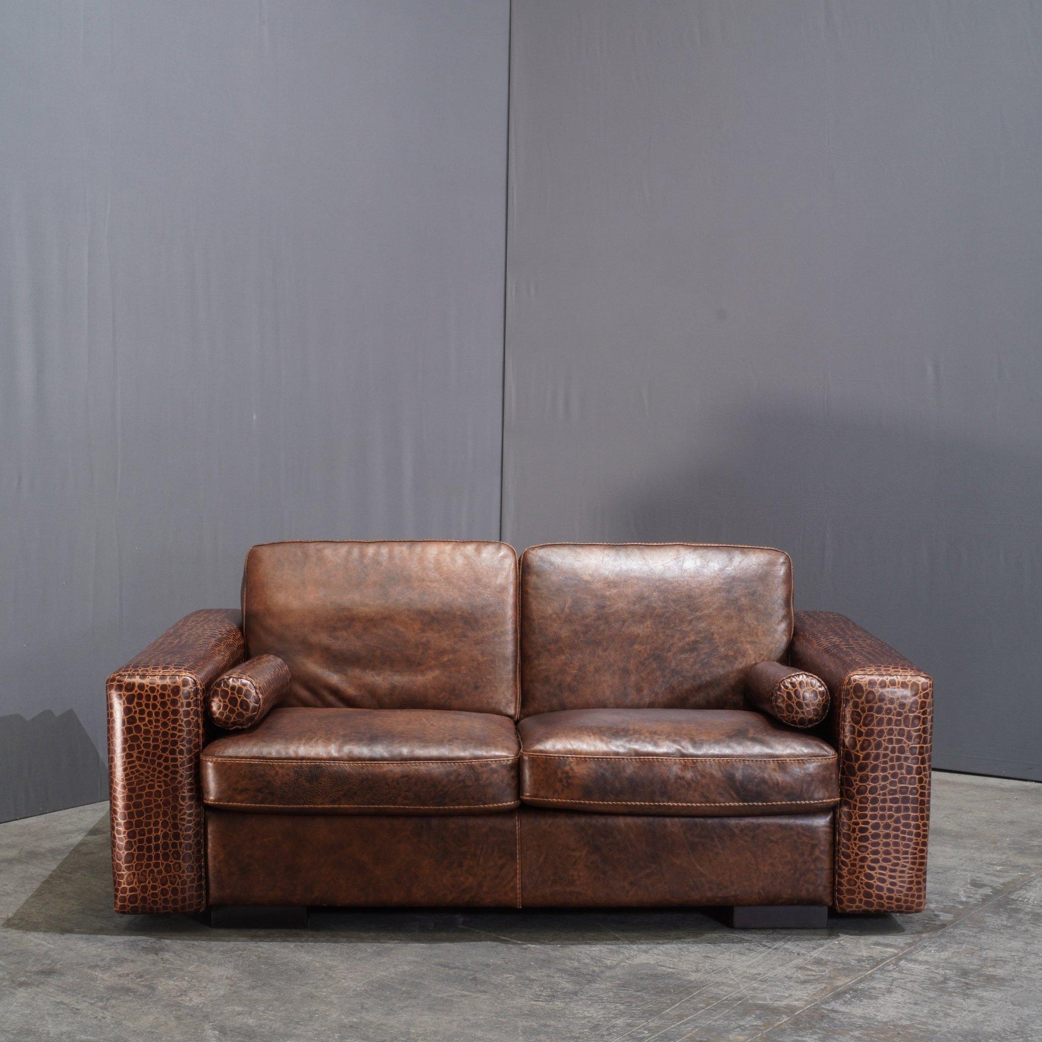 Le canapé Kelly 2 places en cuir crocodile de Gamma Arredamenti est une pièce audacieuse qui respire le luxe et la sophistication. Tapissé de cuir marron exquis à motif de crocodile, ce canapé équilibre parfaitement le design contemporain et le