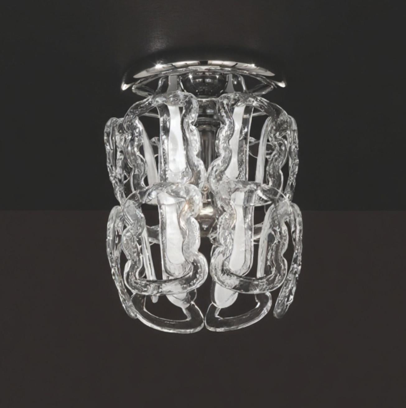 Montaje empotrado italiano mostrado con ganchos de cristal de Murano transparente decorados con rayas blancas en el centro, montados en un marco de metal con acabado cromado / Fabricado en Italia
1 luz / tipo E26 o E27 / máx. 60W
Medidas: Diámetro
