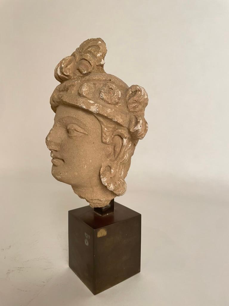 Stucco head of a Bodhisattva, Gandhara, 3rd - 5th century AD. Mounted on a custom made brass base. 
12 inches high ( head alone 8.2 in ) 5.5 wide 5 deep
Provanance: Ex Sotheby's, old tag on bottom of base. 

The Bodhisattva with heavy-lidded almond