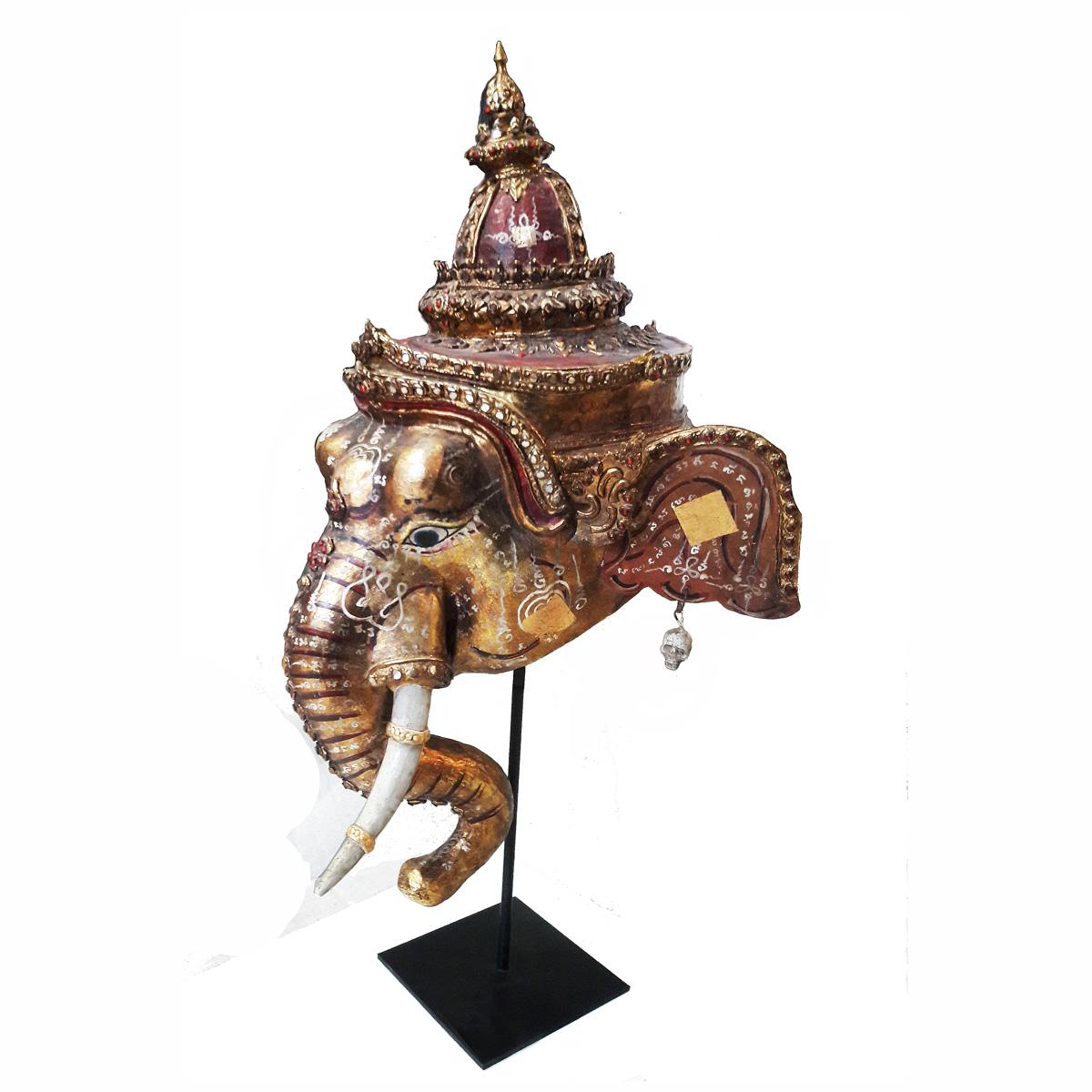A Thai Khon Dance Drama mask of Ganesha, a Hindu deity, patron of the arts, remover of obstacles and the Deva of wisdom. Early 20th Century. Polychromed wood and paper mâché, with stone insets. Mounted on a black metal stand.