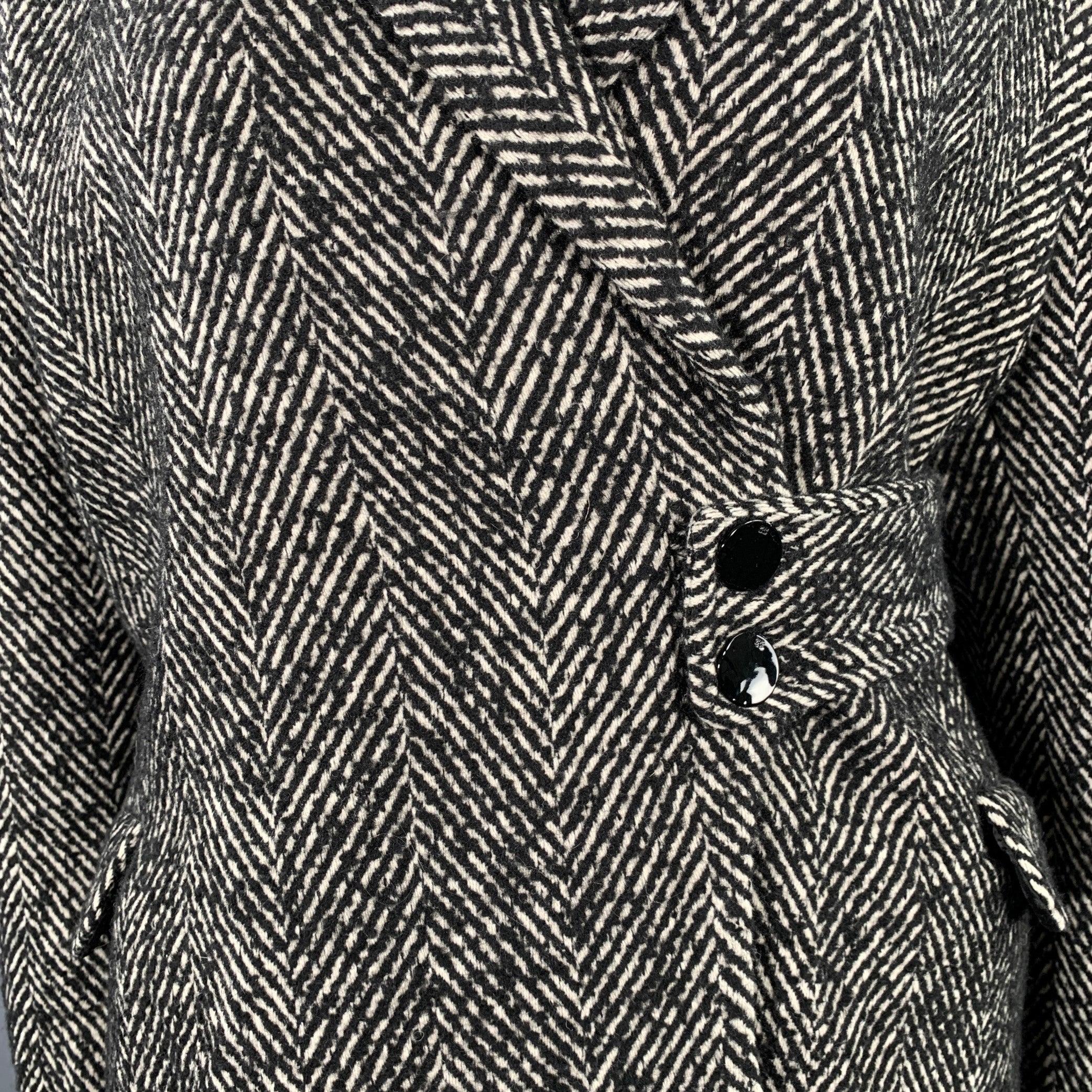 GANNI coat
in a grey wool blend tweed featuring a peak lapel, belted design, and double button closure. Excellent Pre-Owned Condition. 

Marked:   46 

Measurements: 
 
Shoulder: 19.5 inches Bust: 46 inches Sleeve: 25 inches Length: 31 inches 
  
 