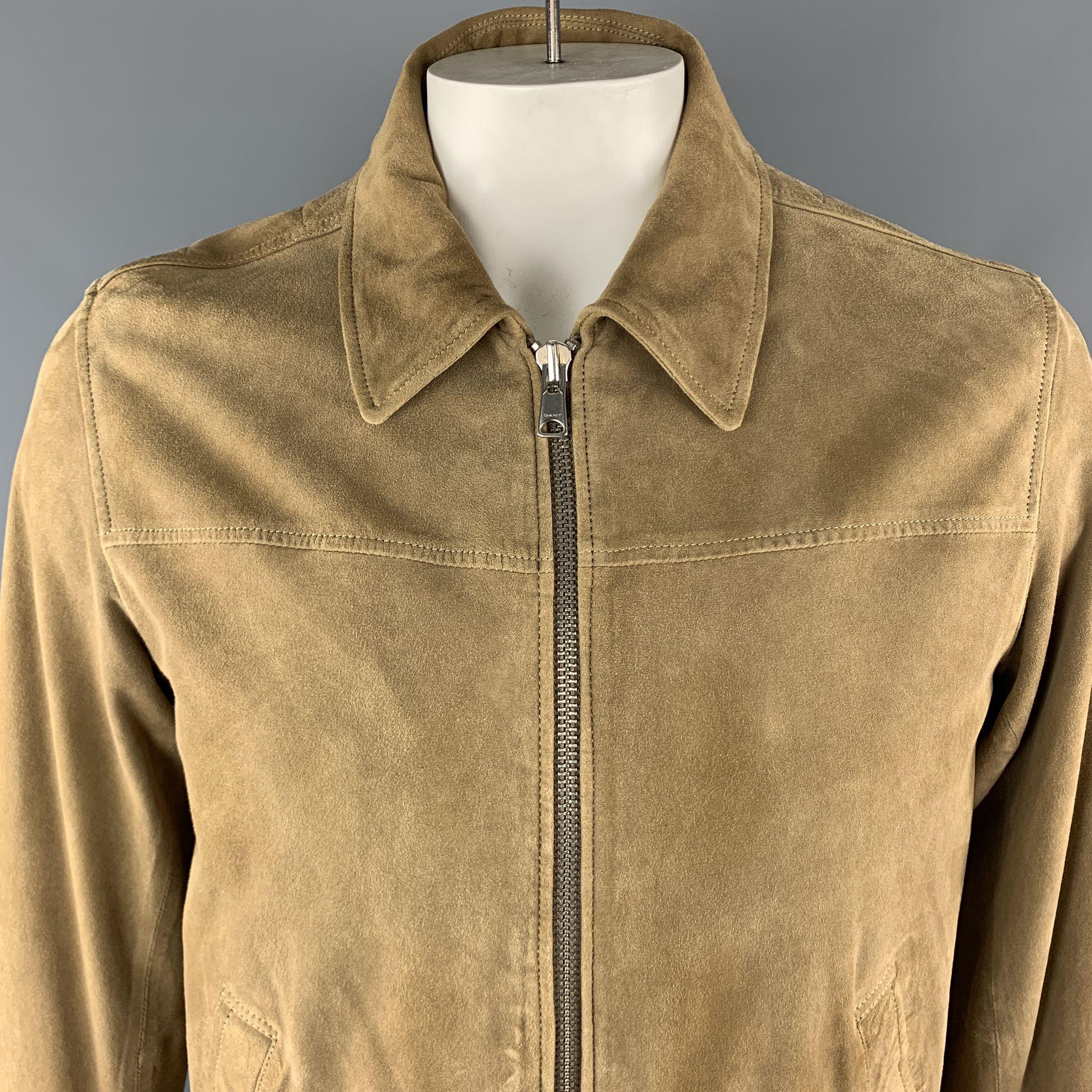 GANT Bomber Style Jacket comes in a tan tone in a solid suede material, with a classic collar, zip up, slit pockets, internal pockets, checkered lining, and buttoned cuffs.

Excellent Pre-Owned Condition.
Marked: L

Measurements:

Shoulder: 17.5 in.