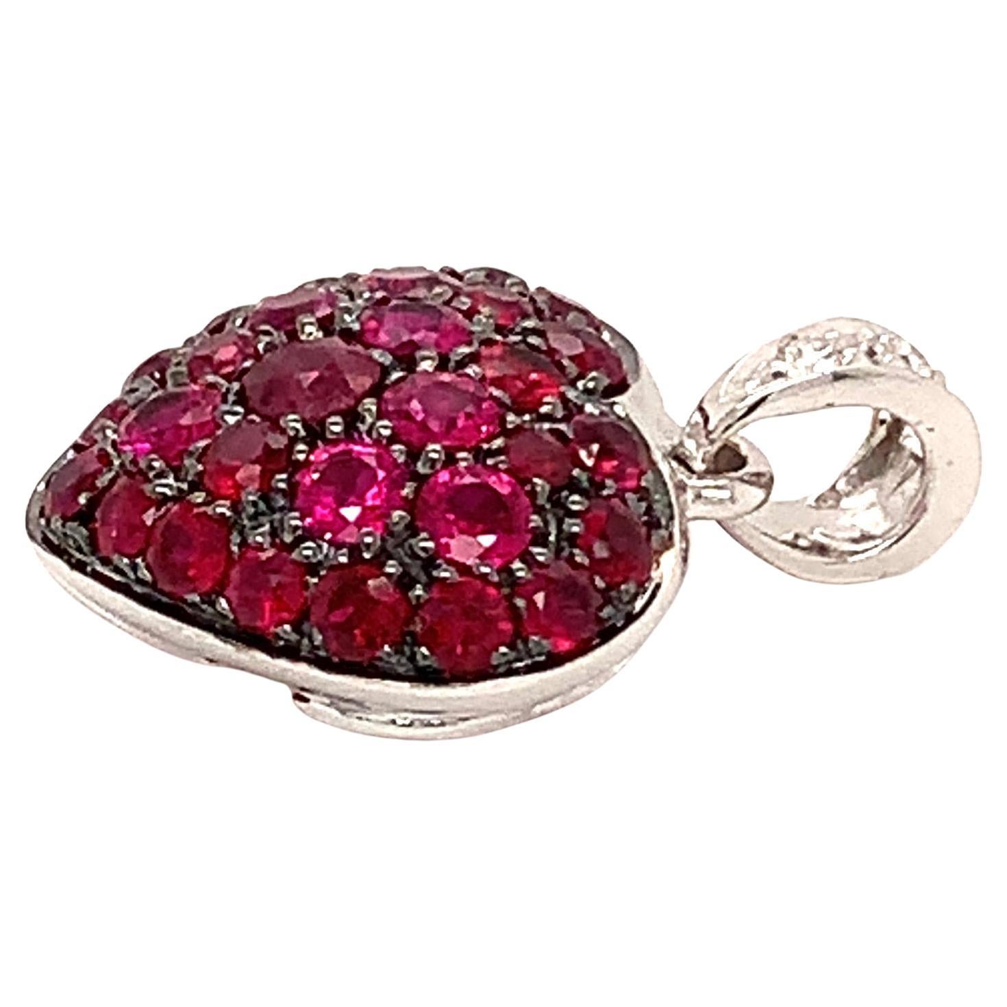 Garavelli  18 Karat White Gold Pavè Ruby Puffed Heart Pendant with White Diamonds Bale.
The Heart featurs a very nice pavè cushion of rubies of different sizes, degrading from a center large stone to the sides; it's black finished to create a strong