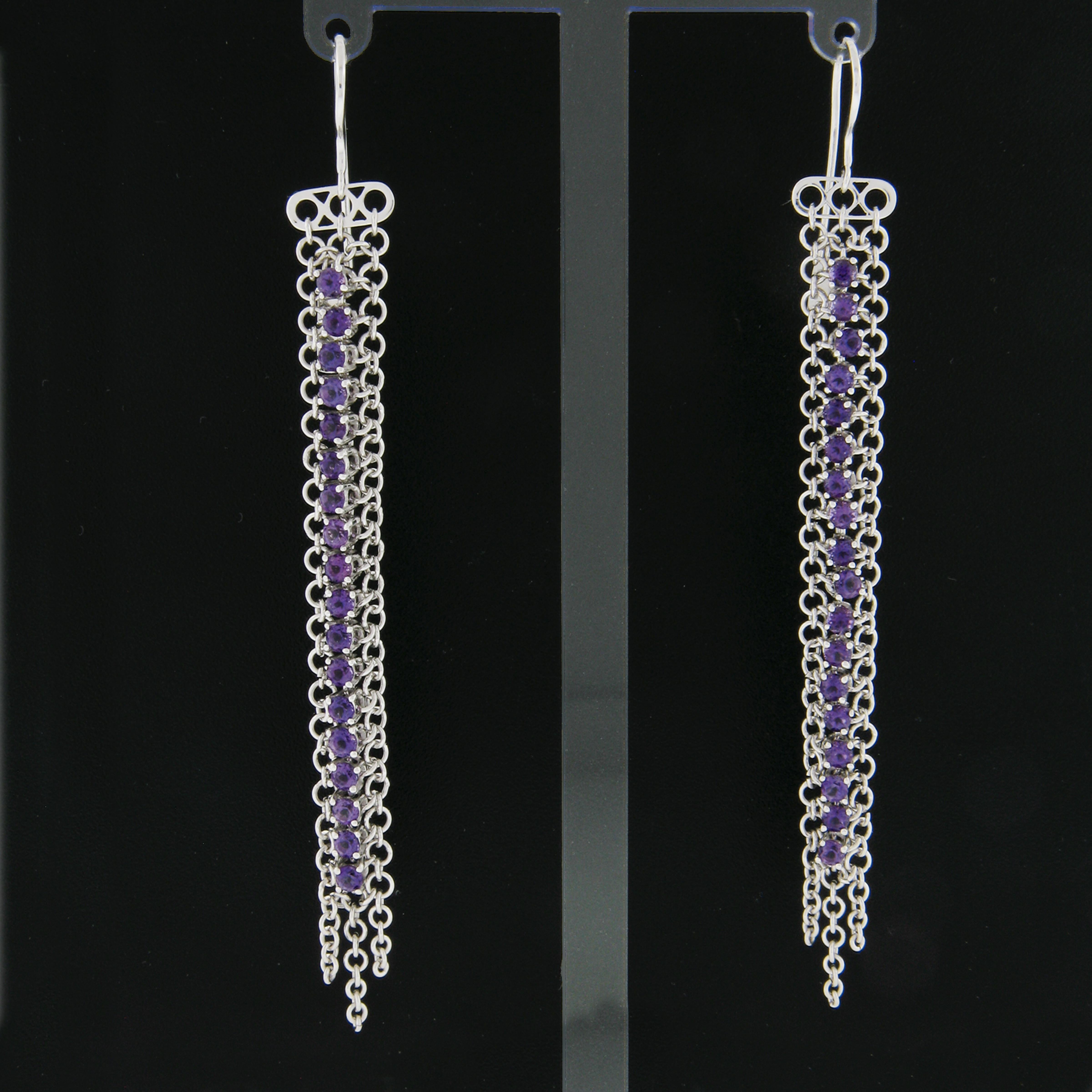 Here we have an Italian stylish pair of long drop dangle hook earrings crafted in solid 18k white gold. They each feature a cable link chain adorned with natural  amethyst, that beautifully sits at the center of the design. The stones have a very