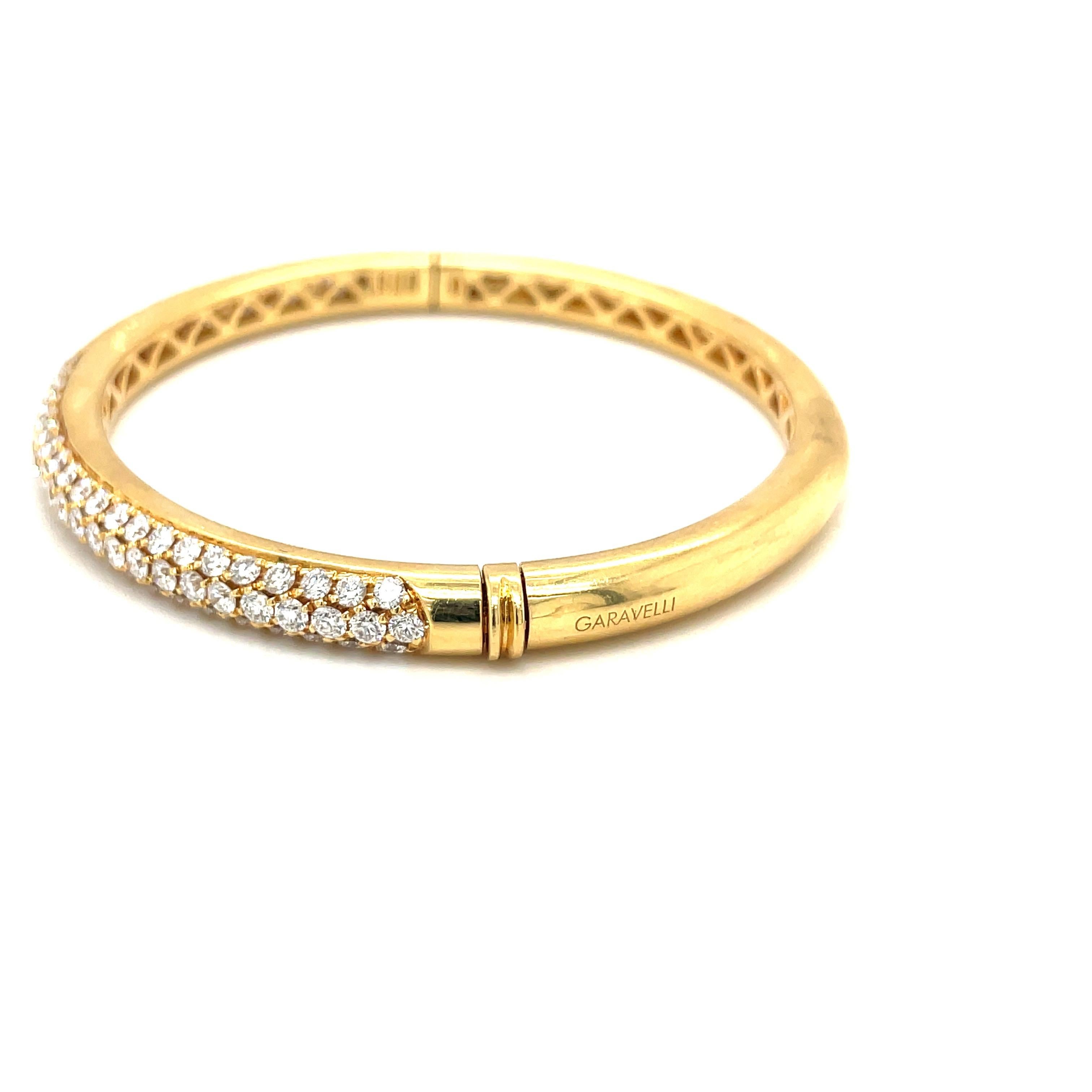 Crafted in Italy by Aldo Garavelli this  18 karat yellow gold bangle bracelet is  pave' set with 3.90 carats of round brilliant diamonds. The oval shaped bracelet measures 2.25