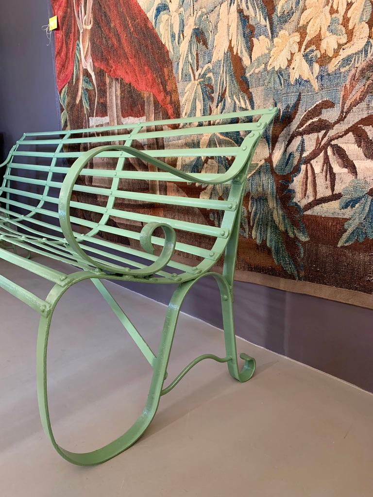 Antique French riveted wrought iron garden bench. Can be used and admired indoors as well as outdoors. The iron bench has great patina, although it has been repainted with rust resistant paint. The bench has great weight to it, but the twists and