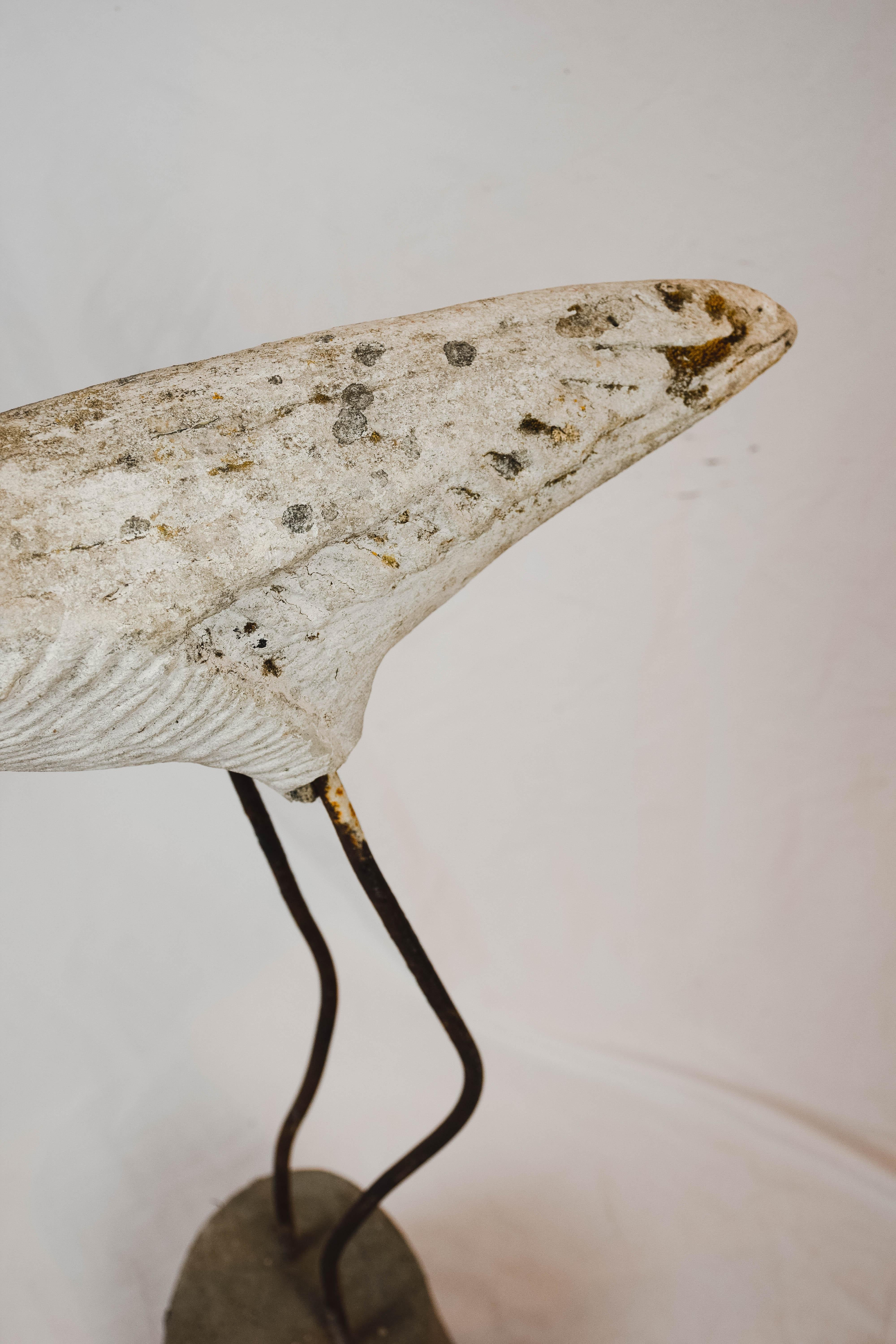We found this charming concrete flamingo in France. Heavy and sturdy, the concrete bird stands solidly on legs made of iron sunk into a concrete base. The body of the flamingo retains much of its original paint which has been worn and dulled by age
