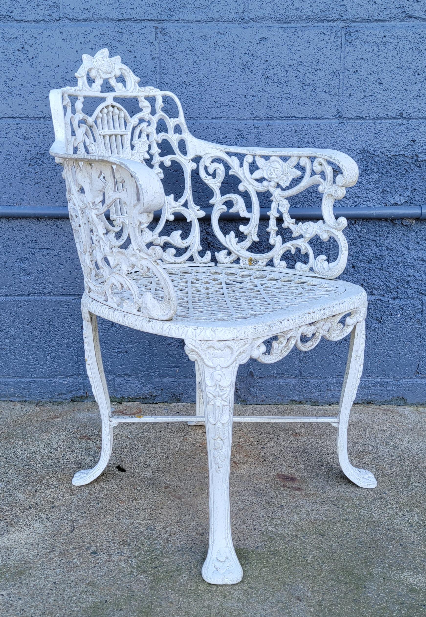 A set of 4 cast aluminum garden chairs in the manner of Robert Wood. Floral and lyre design, removable seats. Mid to late 20th century. Original white paint with patina; light wear, dust and dirt from outside use. Structurally very solid. Arm height