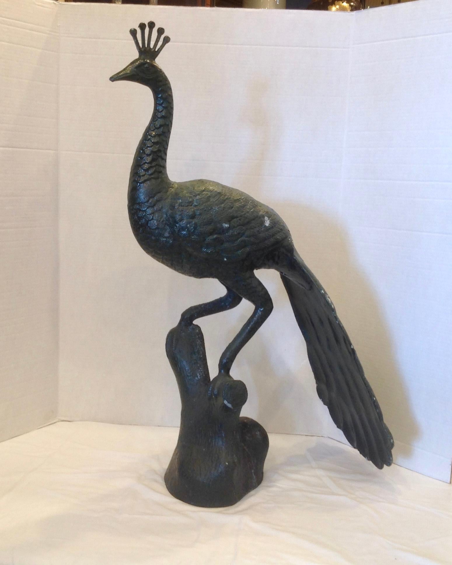 A life-size figure perched on a branch.
The piece is finished with a black color with greenish hue - unusual.