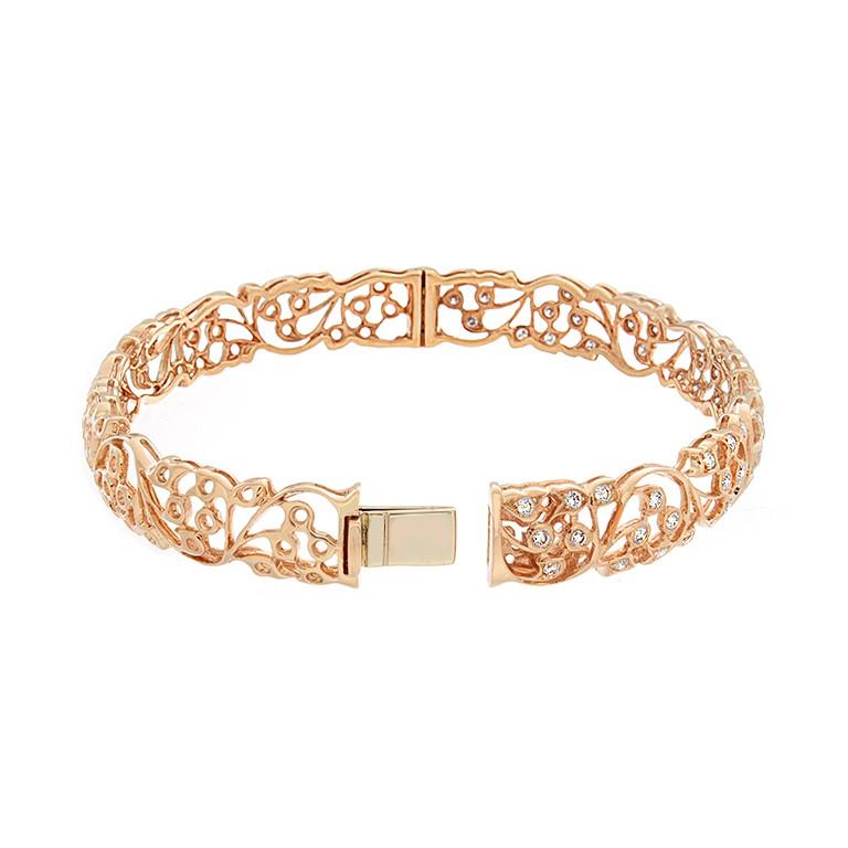 An intertwined garden motif featuring 1.12 carats of VS quality round cut diamonds bezel set in 14K rose gold. The diamonds go half way around, but the gold flower motif goes all the way around.  It has a box clasp ensuring a secure closure.

Fits