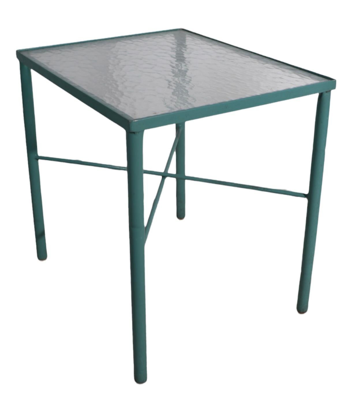 Petite table d'appoint chic en peinture aqua d'origine, avec plateau en verre texturé d'origine. Le cadre est en aluminium tubulaire, et conserve ses pieds dômes en plastique d'origine. Cette table fait partie d'une grande série de meubles de patio,