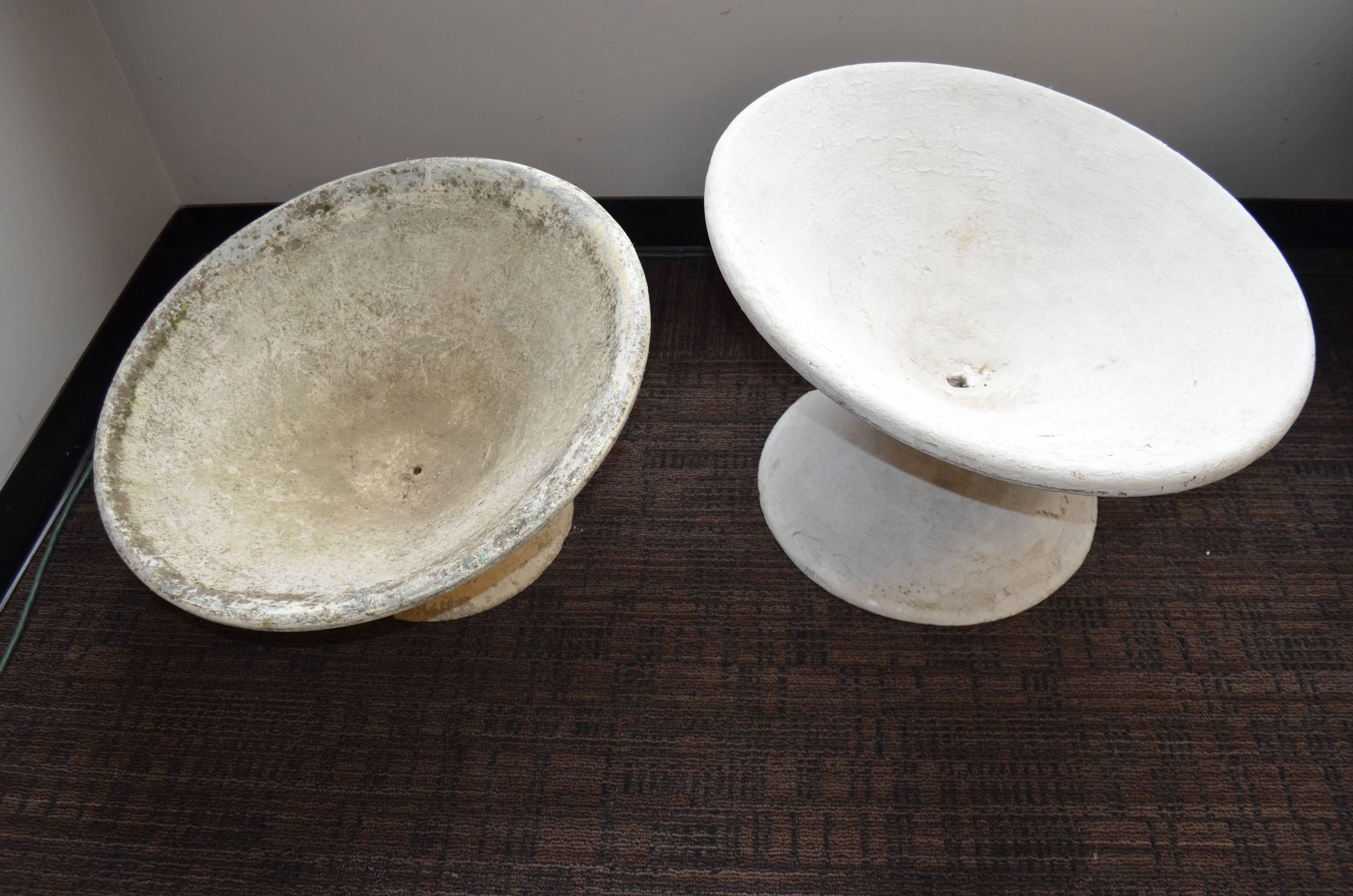 Willy Guhl garden planters of saucer formed stone. One previously painted. One natural offered as a pair. Quite the rare offering from the famed Swiss designer. Paint can be easily removed from the one if desired. We like the contrasting color