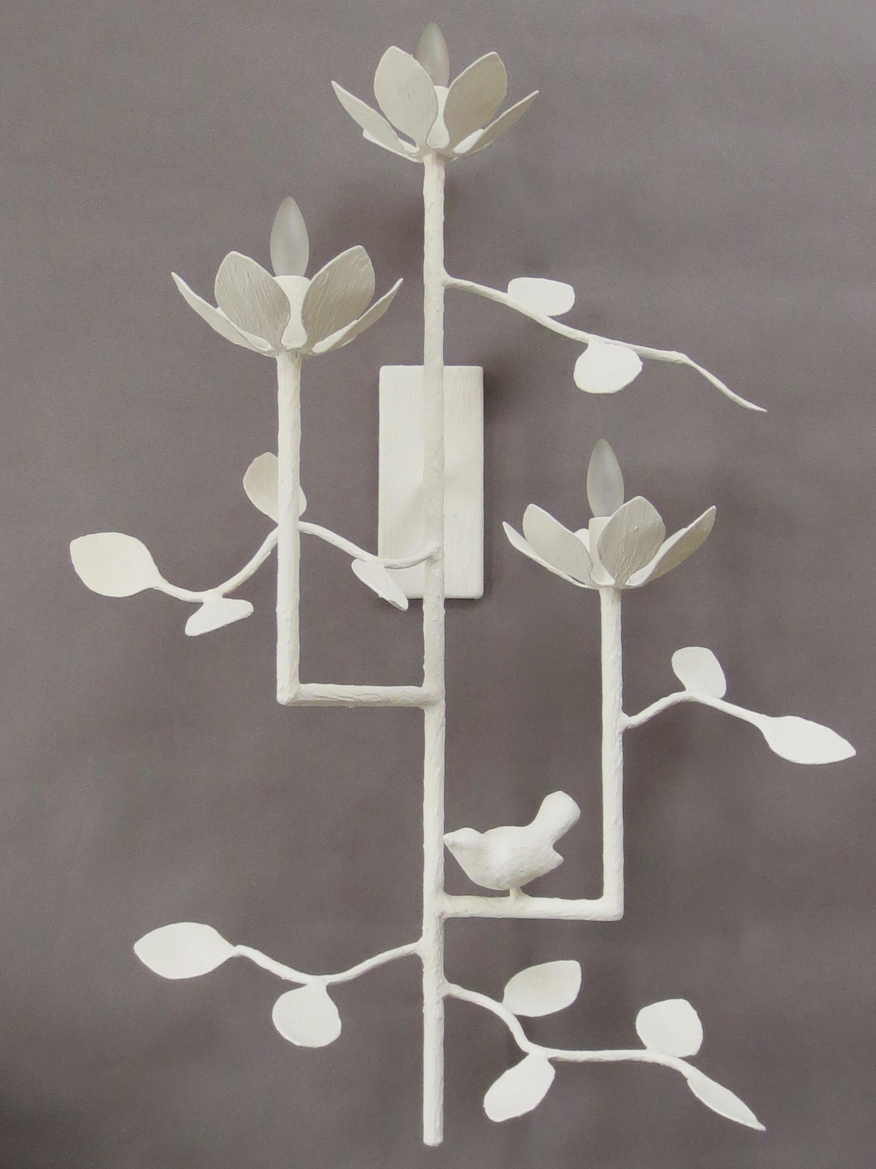 Garden Plaster Sconce  by Tracey Garet of Apsara Interior Design.
The Garden Sconce has 3 blooms on varying levels and is shown in a white plaster. Branches and leaves are detailed throughout with a single bird. Each bloom contains a candelabra