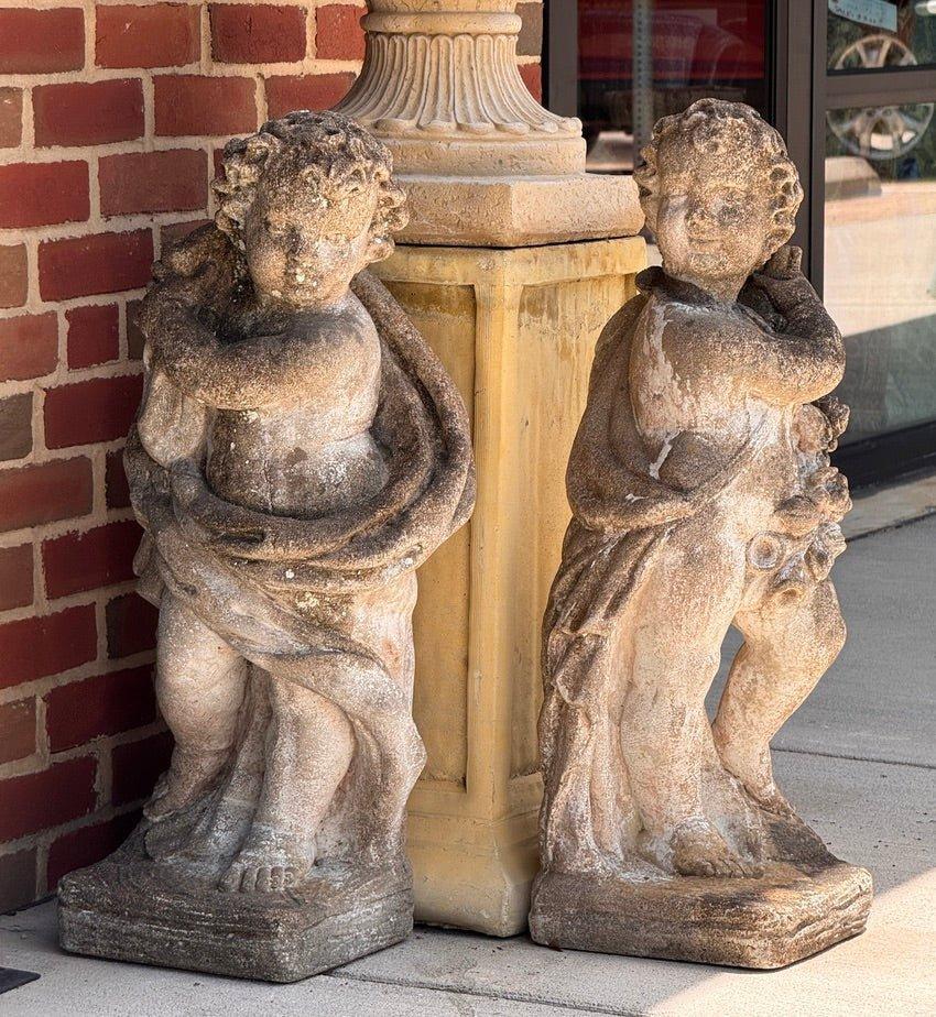 Un'affascinante coppia di putti in pietra fusa con drappeggi classici e ghirlande di frutta, riccamente esposti agli agenti atmosferici. Italiani, inizio del XX secolo, ideali come segna cancelli o come elementi decorativi per il giardino. 28
