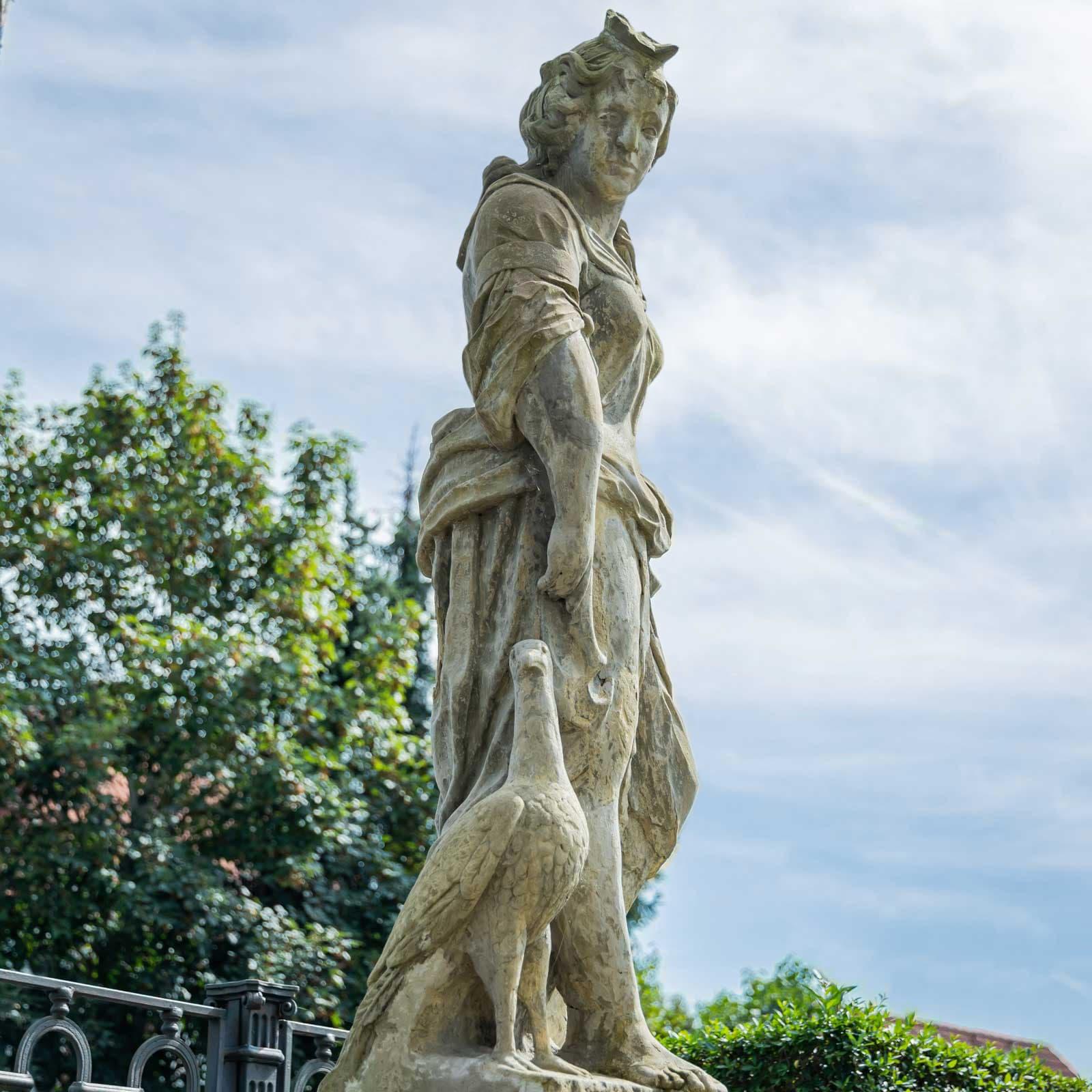 Sculpture grandeur nature d'un chasseur en habits baroques au visage douloureux et au geste de se serrer la tête. Il vient d'être mordu à l'avant-bras par un chien de chasse. La sculpture est réalisée en grès et présente une patine naturelle. 