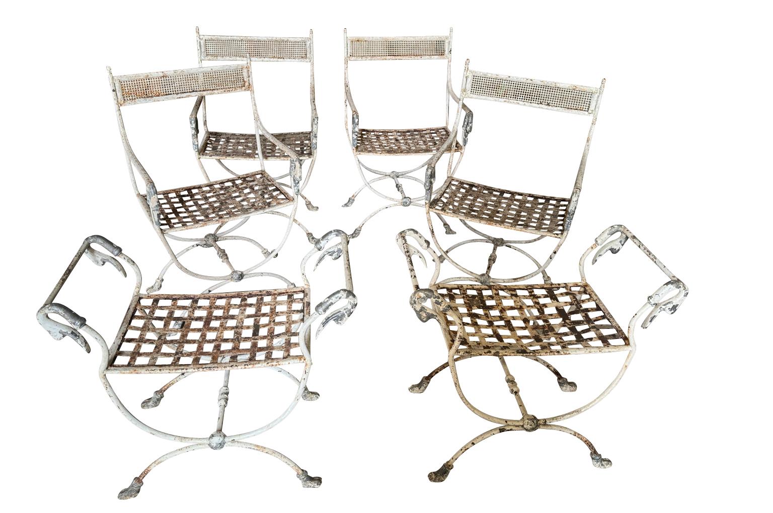 A very lovely late 19th century set of Empire Curule form Garden Chairs and Stools.  The set consists of four armchairs and two stools wonderfully crafted in iron.  Very chic.  Perfect for any garden or interior.  The armchairs measure 32 1/8
