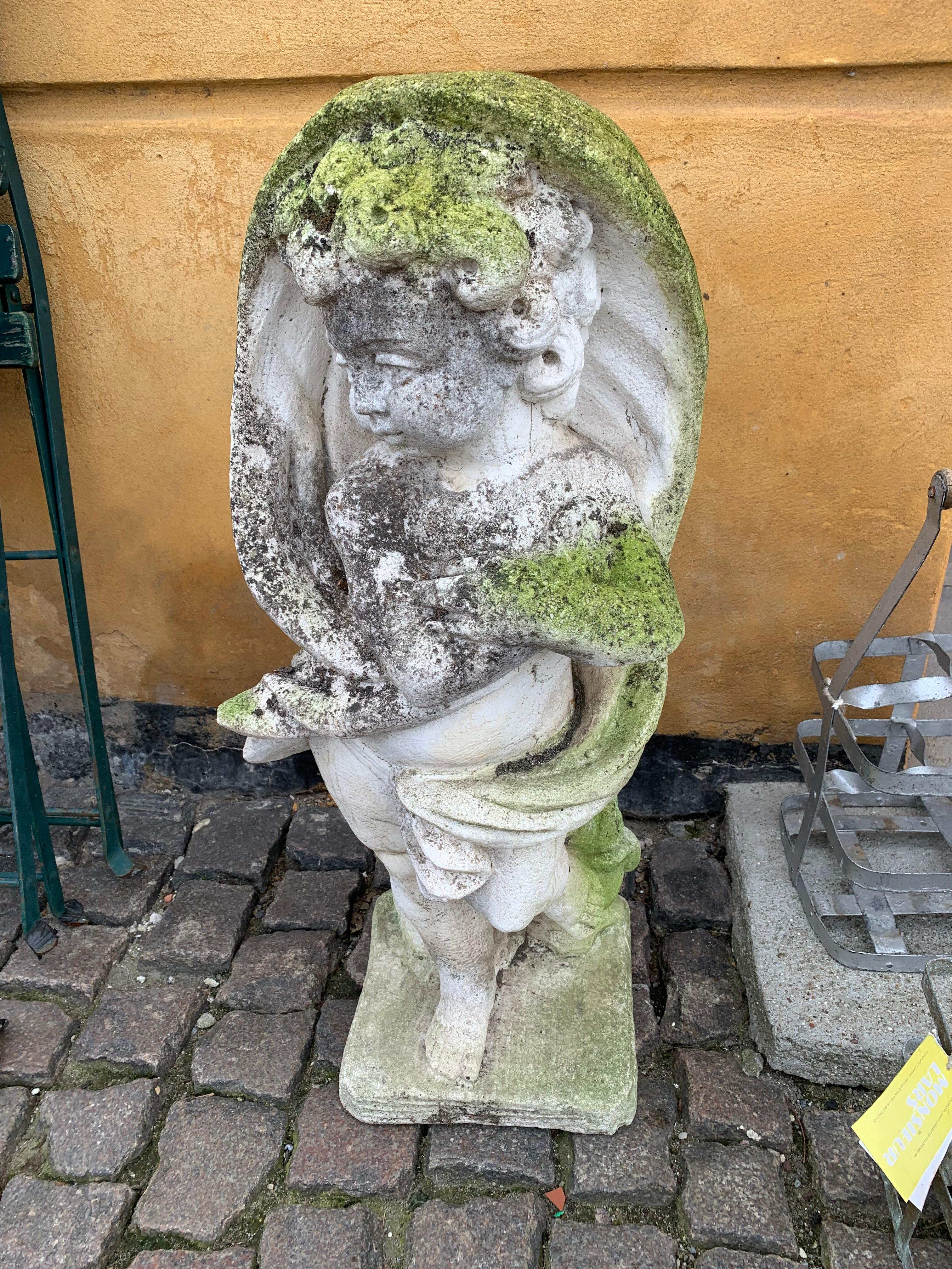 Wonderfully patinated stone cast putti - for the adding romantic ambiance to your garden, balcony or interiors.