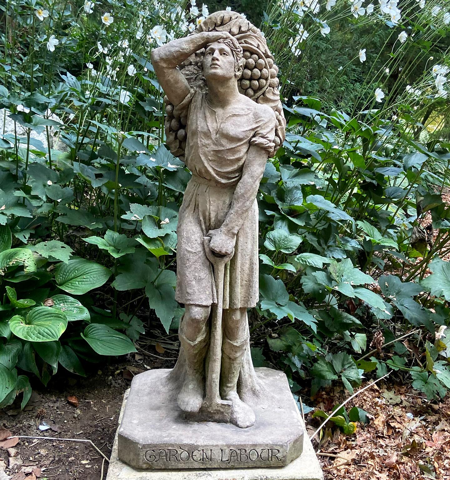 A stoneware figure in the Arts and Crafts style, inscribed “Garden Labour”, depicting a worker with one hand gripping the handle of a shovel, the other hand on his brow, his back against a Doric column entwined with stylized grapevines, attributed