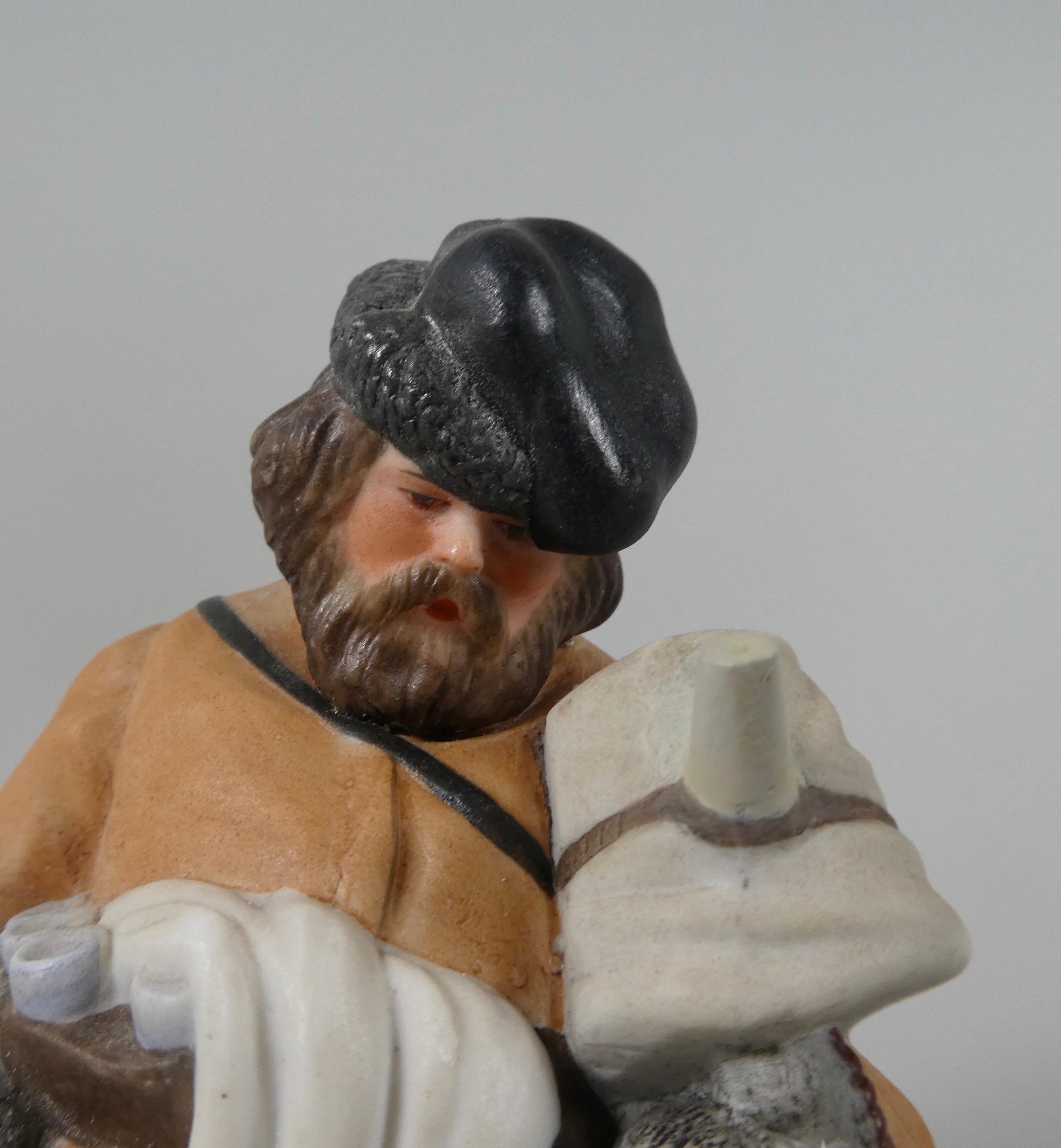 Gardner of Moscow biscuit porcelain figure, c. 1870. Modelled as a Sbitenschick, or Sbiten Vendor, well dressed against the winter, and carrying his urn in his left hand. His right hand carries bagels, and a flask of vodka, whilst his belt supports