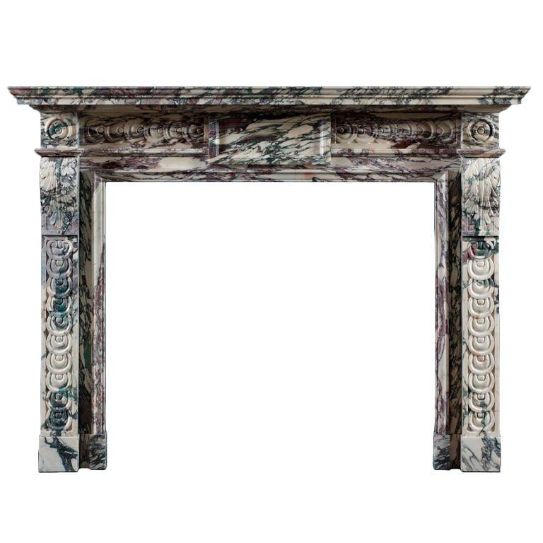 No expense has been spared in producing this beautiful chimneypiece. The shelf and jambs are carved out of solid blocks of Breche in the traditional 18th century manner. The corner blocks, decorated with circular paterae, are carved out of one piece