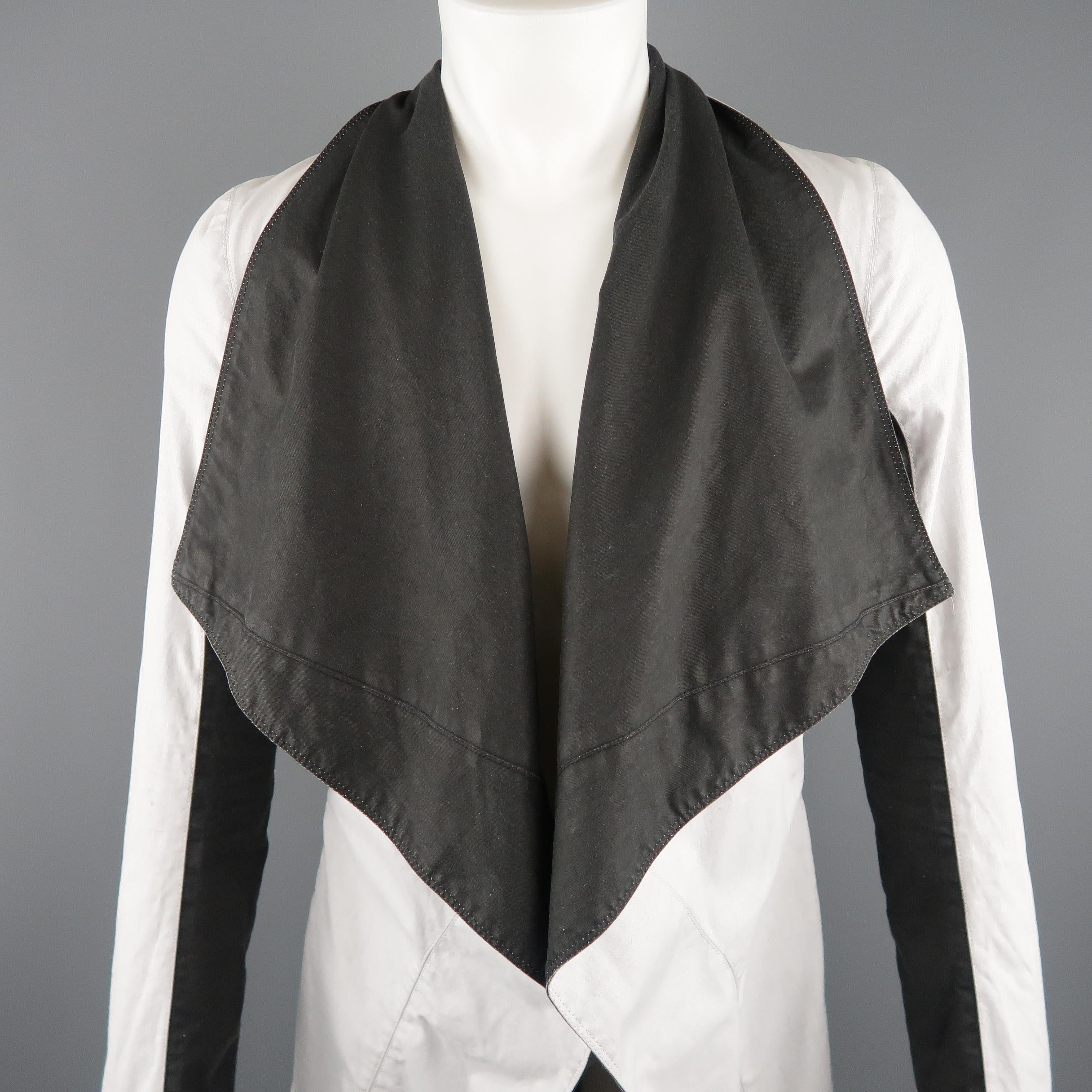 This rare GARETH PUGH coat comes in off white stretch cotton fabric with a draped, oversized black collar lapel, under arm color block panels, and tied closure. Fading and minor wear. Made in Italy.
 
Good Pre-Owned Condition.
Marked: IT 46
