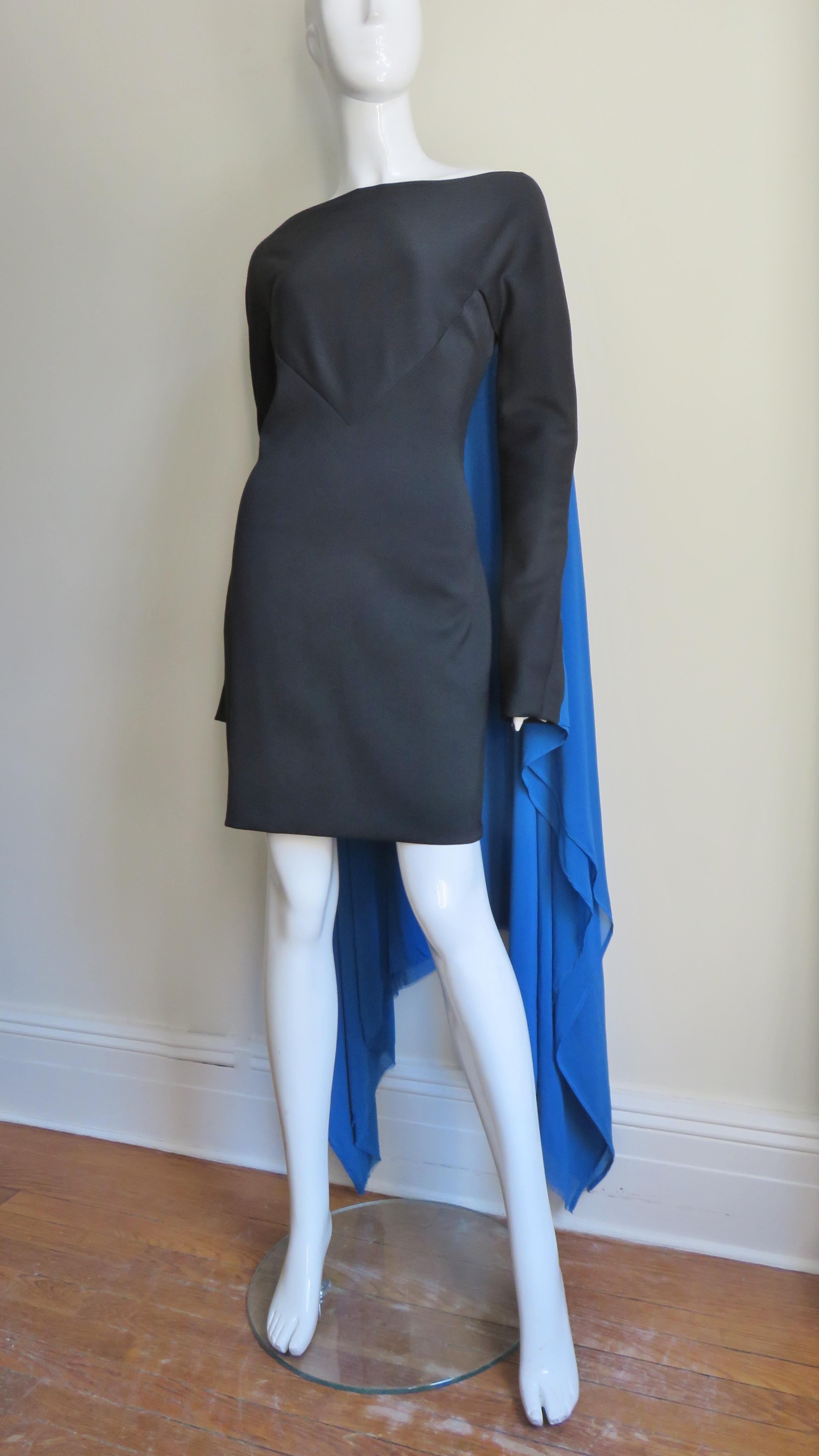 Ein fabelhaftes schwarzes Jersey-Kleid aus einer Wollmischung mit einem leuchtend blauen, 2-lagigen, schalartigen Seidenumhang mit spitzem Saum, der von den hinteren Schultern und Ärmeln herabhängt. Das Kleid hat einen Bateau-Ausschnitt, eine