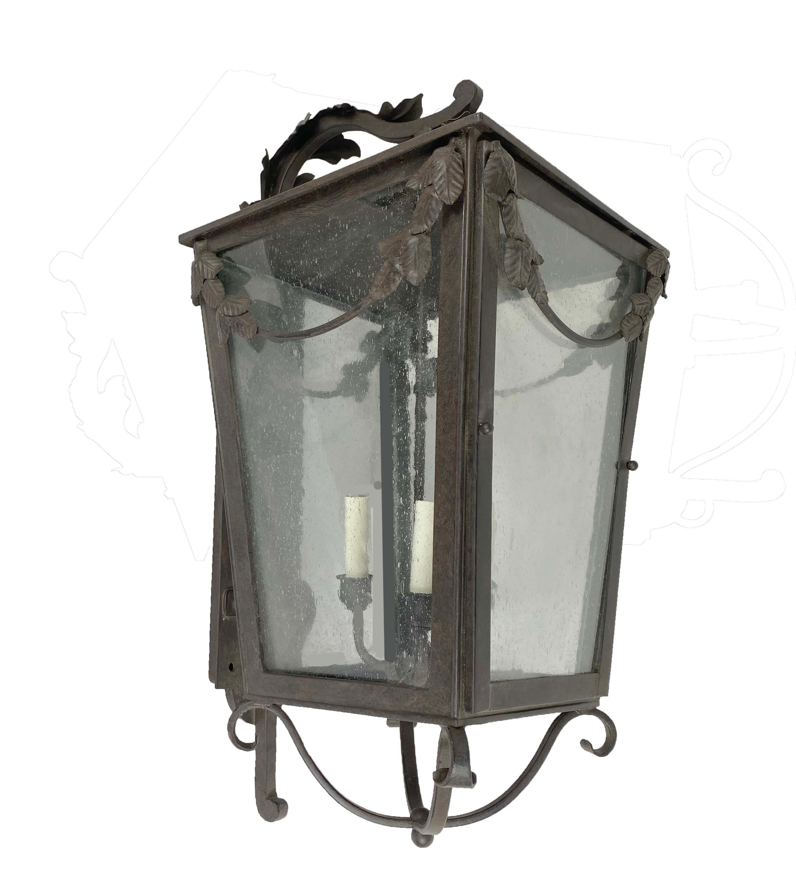The Garland wrought iron wall bracket lantern will be at home on your French Country house. The delicate leaves in the garland sweep and acanthasas leaves on the bracket make this French style lantern a winner. Measure:  12
