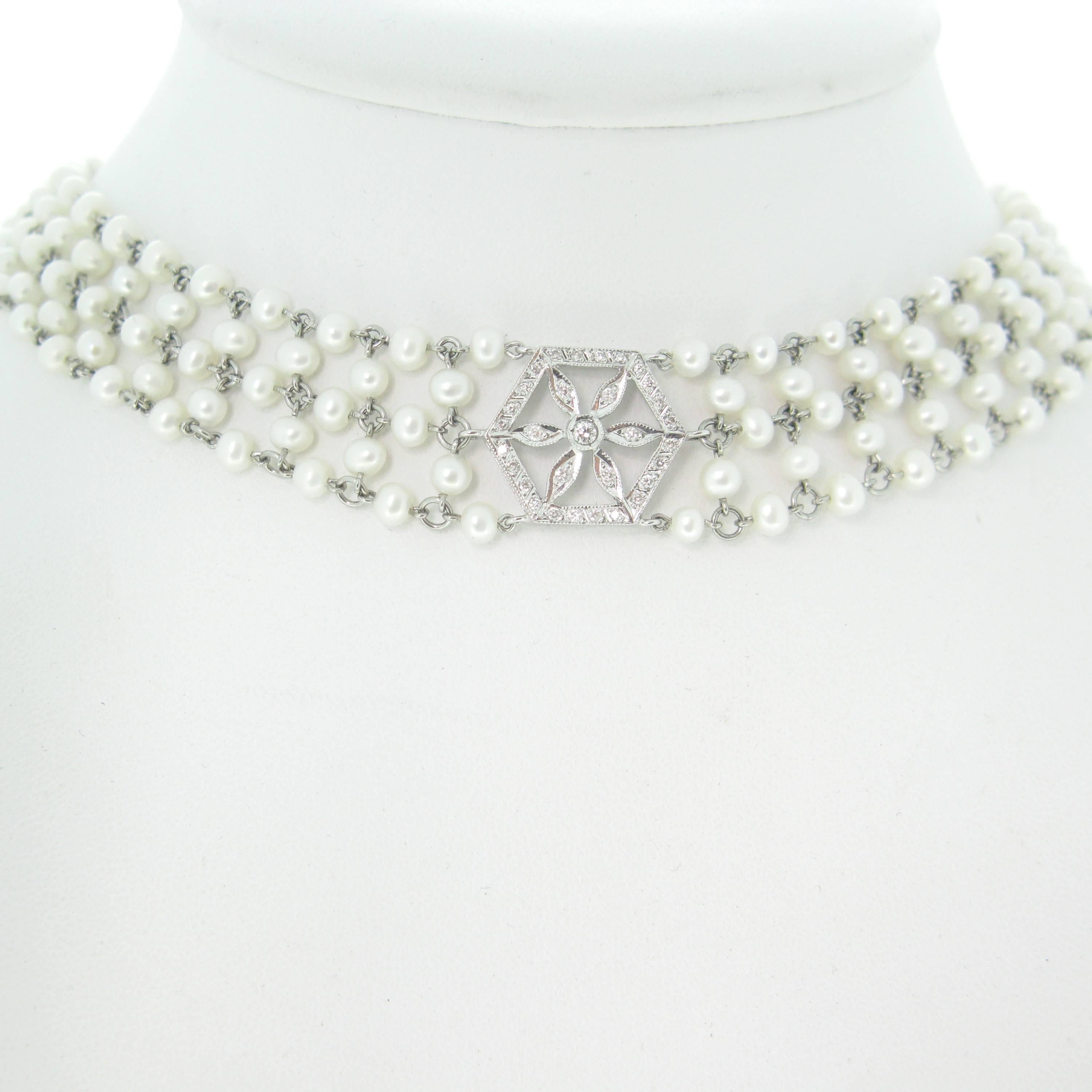 This ravishing necklace consist of five lines of cultured pearls – there are 260 pearls in total. Each pearl has a diameter of about 3.20mm. The motif in the center and the clasp are made in 18kt gold set with round brilliant cut diamonds – there